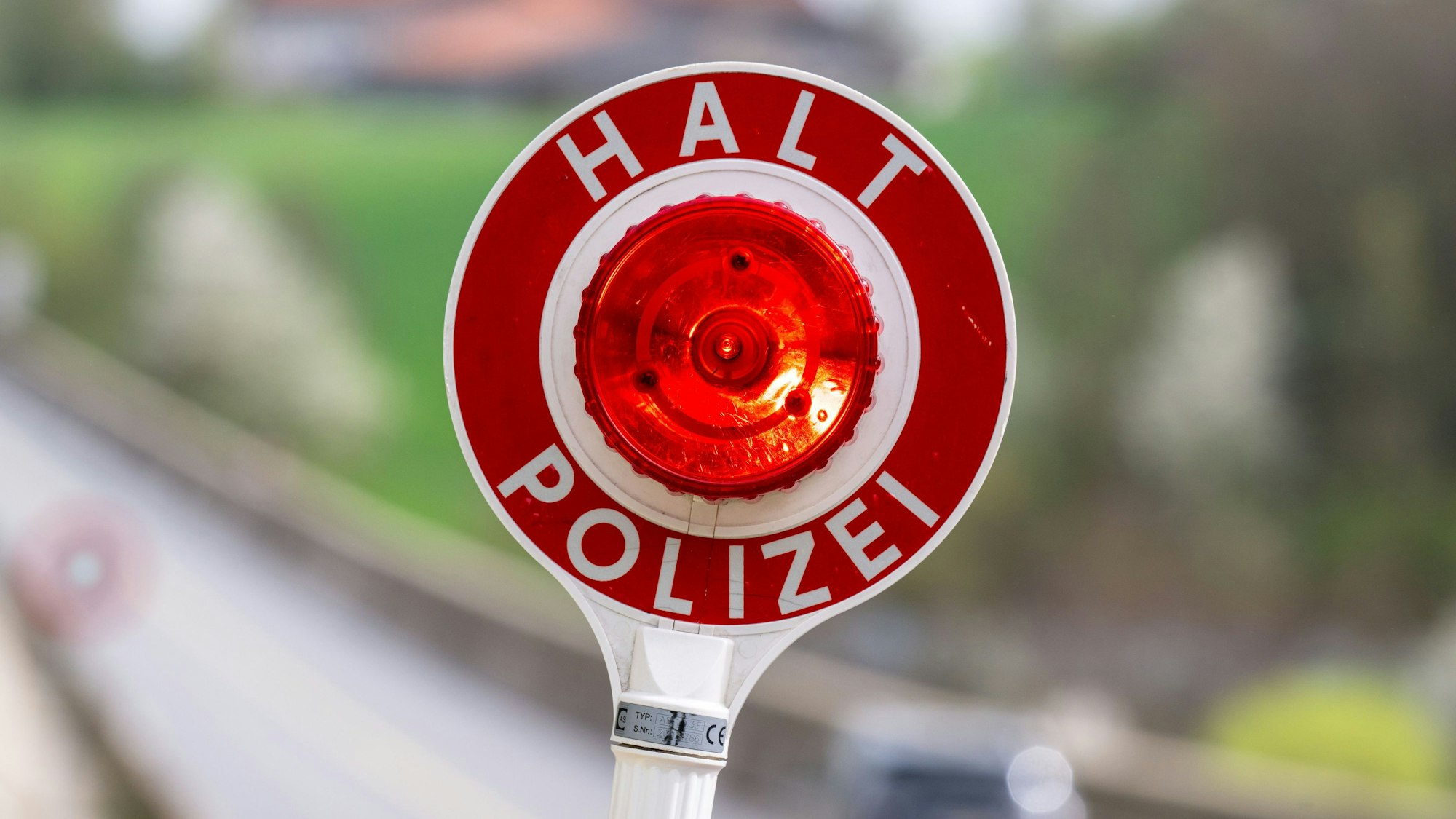Eine Kelle mit der Aufschrift «Halt Polizei» wird während einer Verkehrskontrolle hochgehalten.