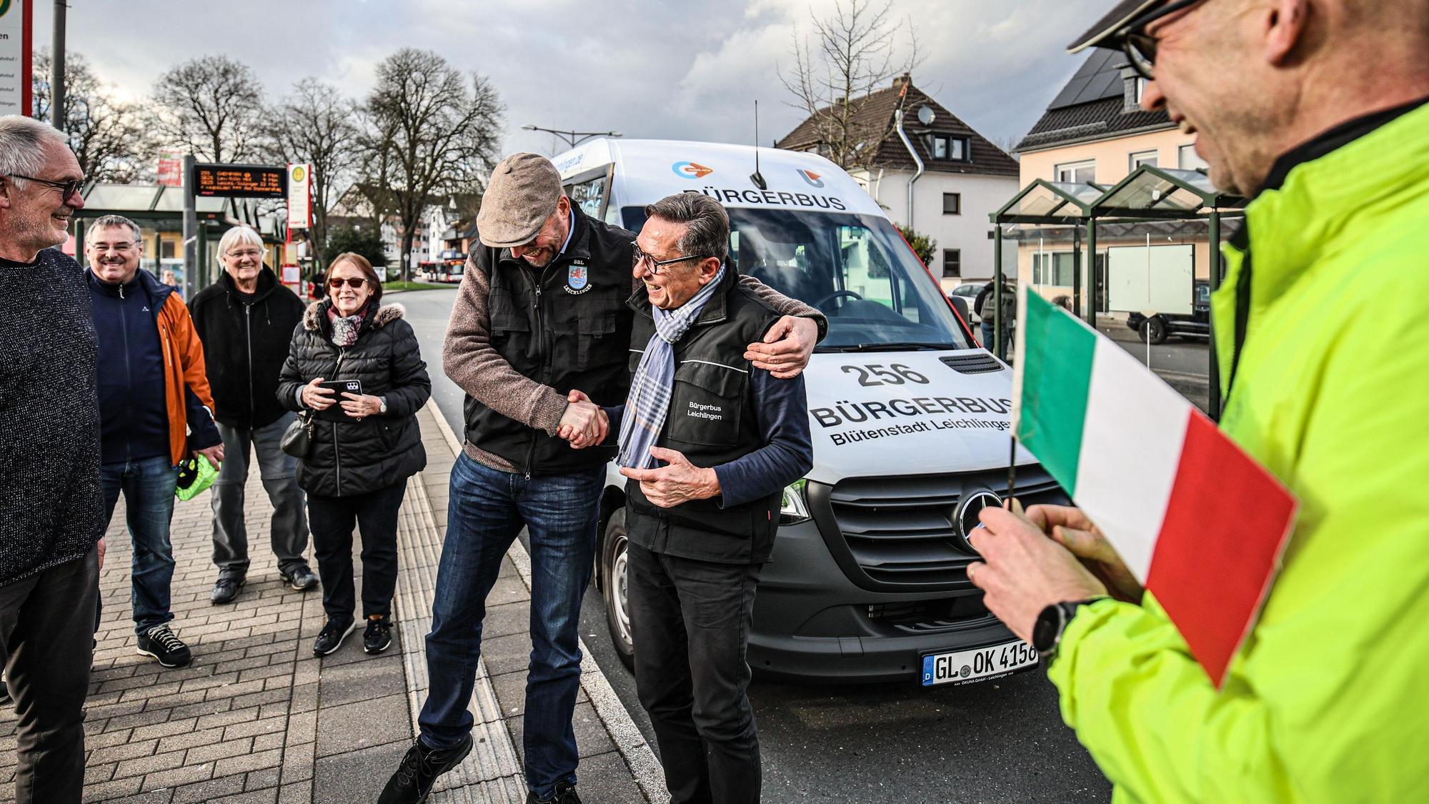 Bürgerbus-Fahrer Toni Fasanella (mit Schal) wird am Busbahnhof von einem Kollegen geherzt.