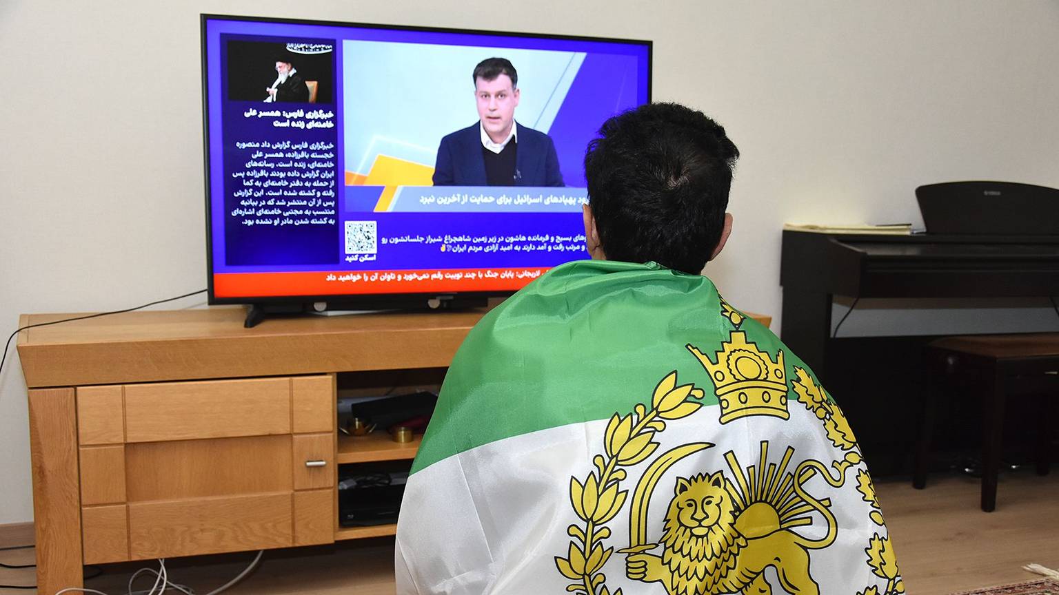 Die Königsfahne auf dem Rücken: Die Entwicklungen im Heimatland verfolgt eine iranische Familie heute im Fernsehen. Vor zehn Jahren ist sie nach Oberberg geflohen.