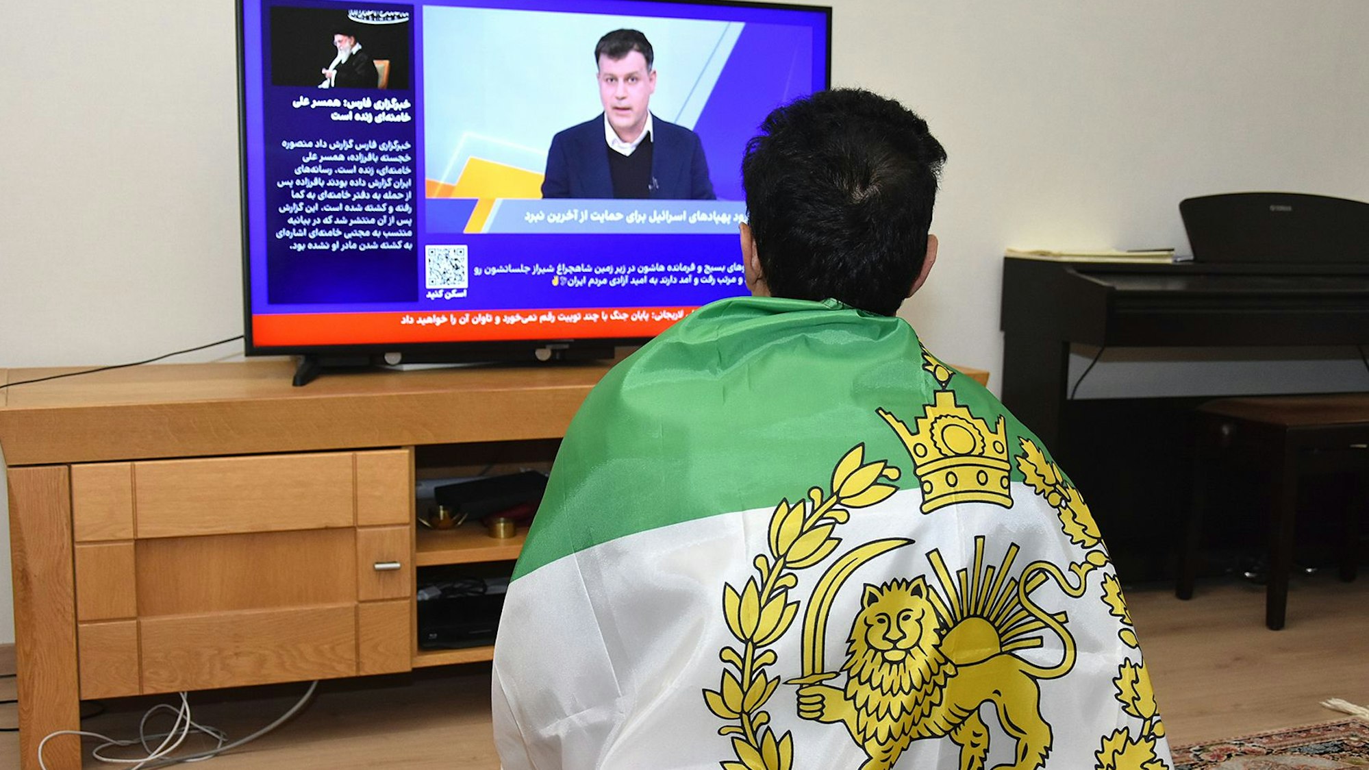 Die Königsfahne auf dem Rücken: Die Entwicklungen im Heimatland verfolgt eine iranische Familie heute im Fernsehen. Vor zehn Jahren ist sie nach Oberberg geflohen.