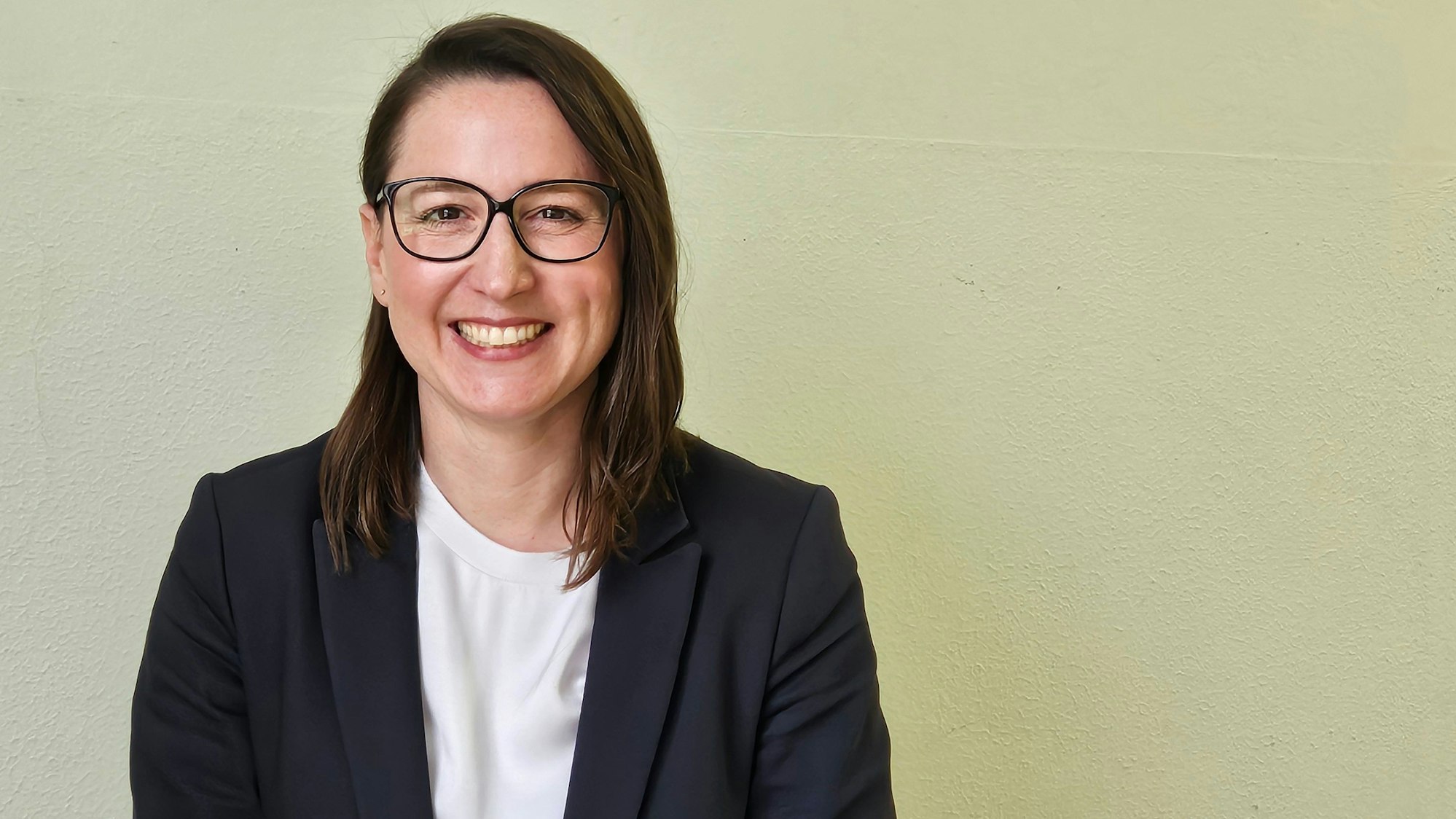 Auf dem Bild ist das Portrait einer dunkelhaarigen Frau zu sehen.