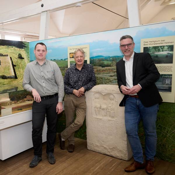 Alexander Mauel (v.l.), Joachim Starke und Norbert Crump stehen vor Stellwänden mit Nettersheimer Motiven.