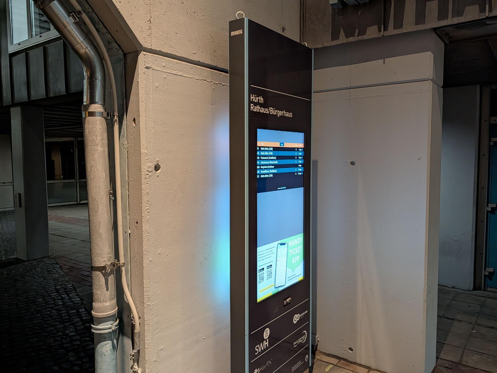 Das Foto zeigt die Stele vor der Wand am Rathaus.