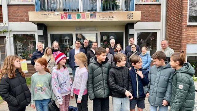 Vom Schulstreit betroffene Eltern und Kinder vor der Hans-Christian-Andersen-Grundschule in Hitdorf