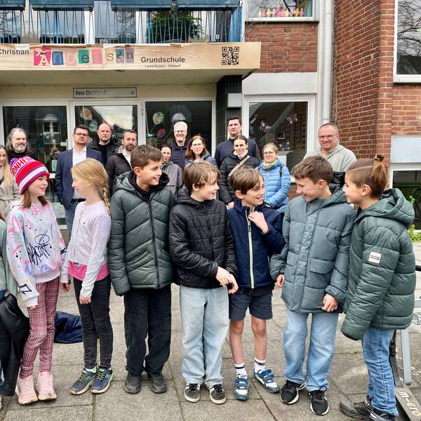 Vom Schulstreit betroffene Eltern und Kinder vor der Hans-Christian-Andersen-Grundschule in Hitdorf