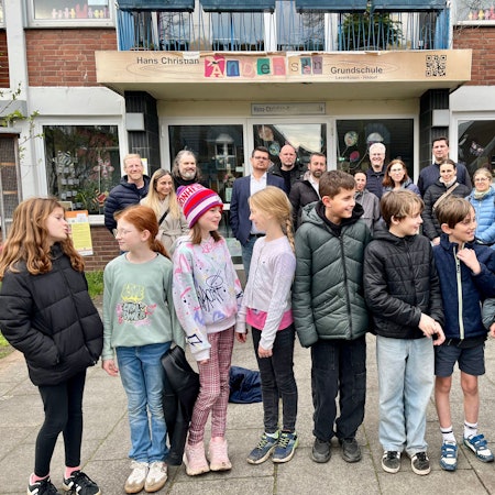 Betroffene Eltern und Kinder haben sich vor der Hitdorfer Hans-Christian-Andersen-Grundschule versammelt.