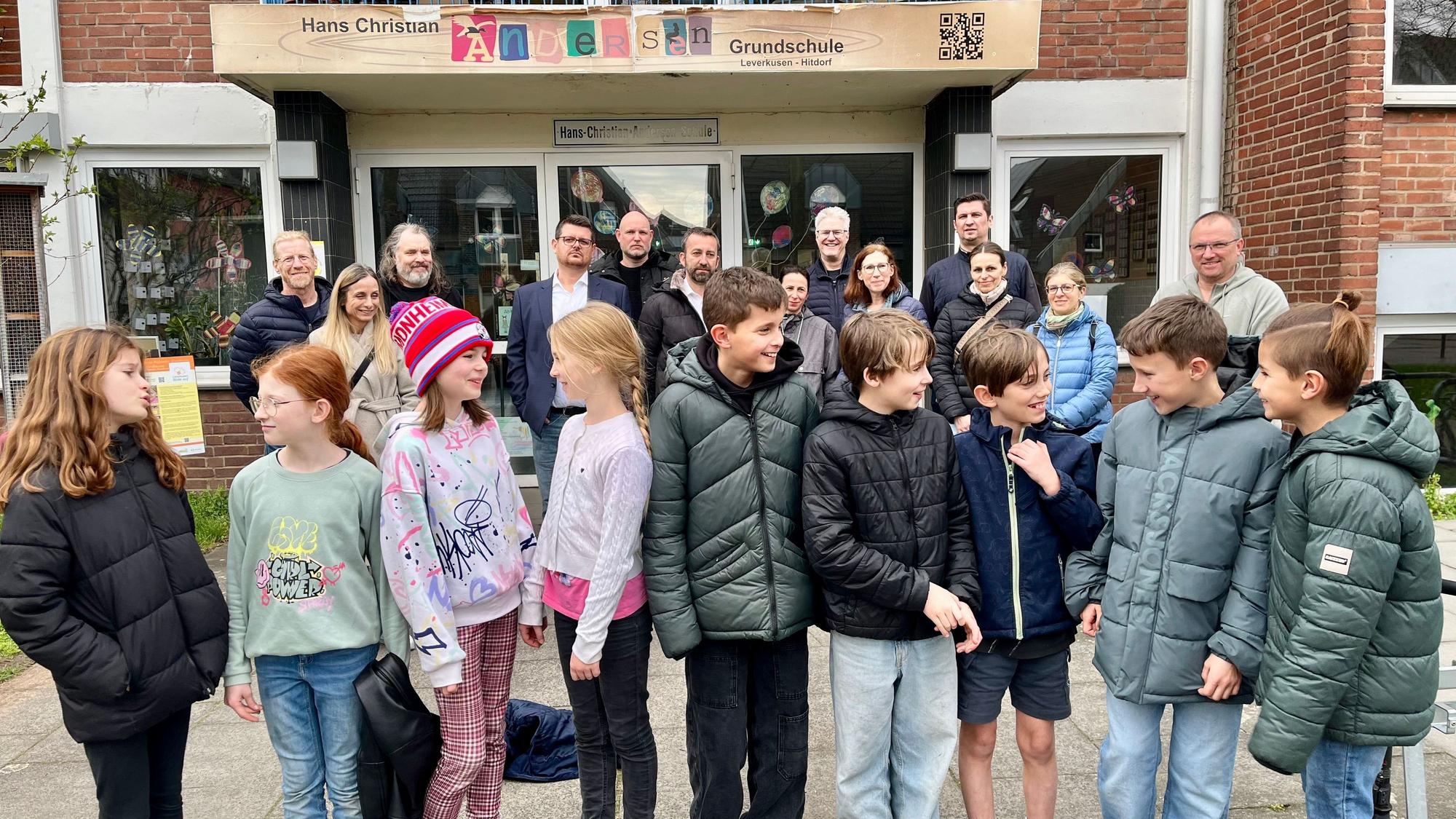 Betroffene Eltern und Kinder haben sich vor der Hitdorfer Hans-Christian-Andersen-Grundschule versammelt.