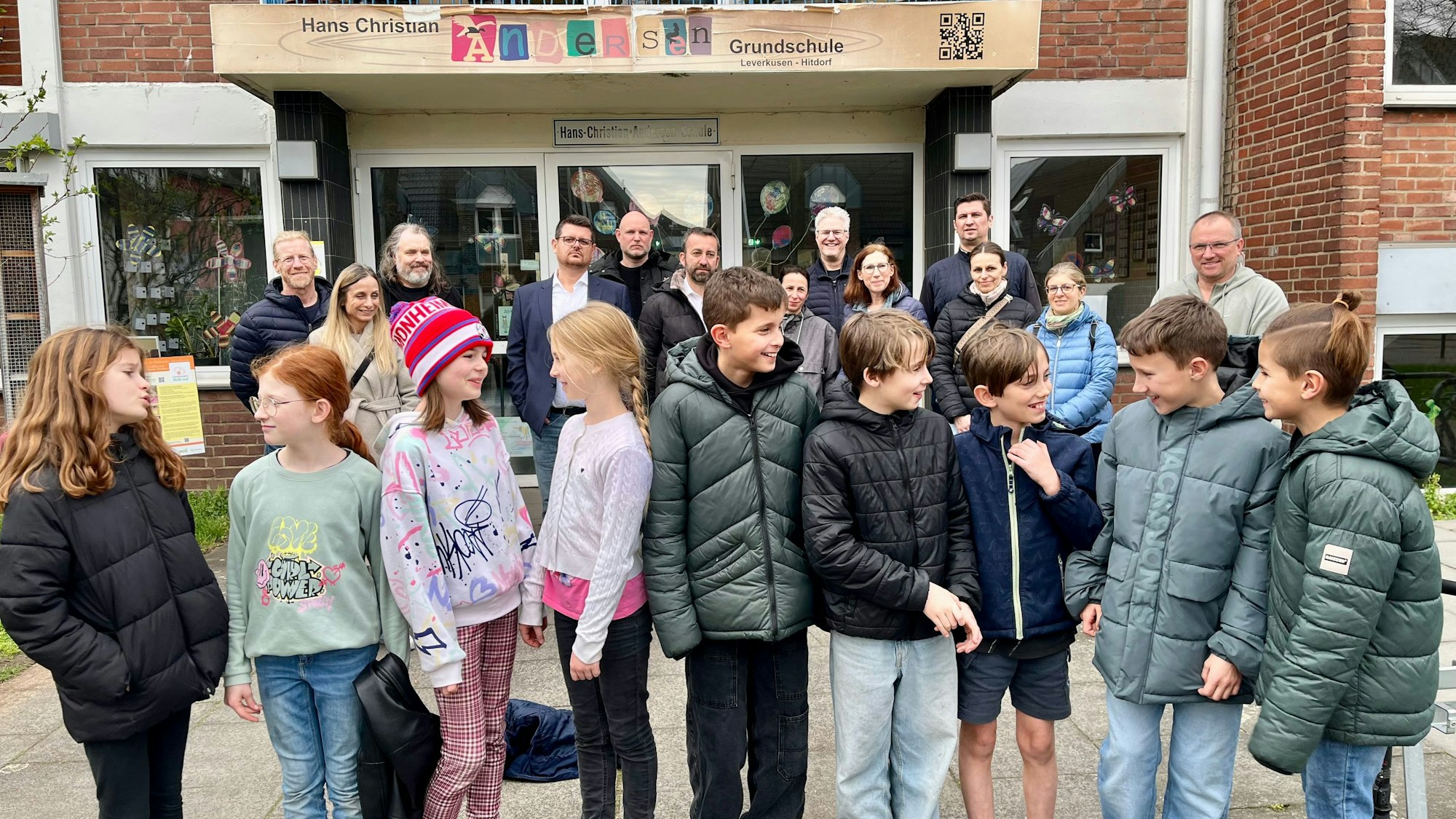 Betroffene Eltern und Kinder haben sich vor der Hitdorfer Hans-Christian-Andersen-Grundschule versammelt.