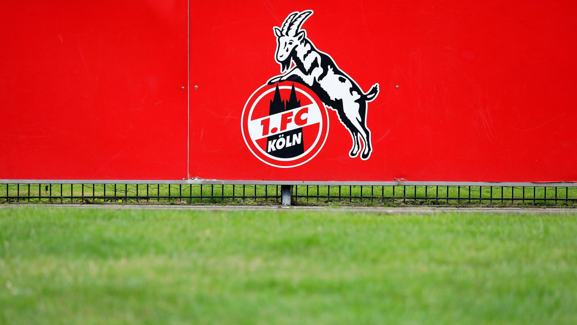 Das Logo des 1. FC Köln auf einer Bande am Trainingsplatz.