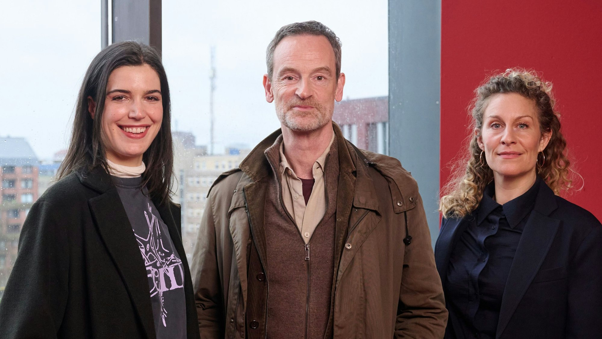 Die neue TV-Kommissarin Sophia Mercedes Burtscher als Hauptkommissarin Leo Sturm, Jörg Hartmann als TV-Hauptkommissar Peter Faber und Alessija Lause als Leiterin der Mordkommission, Ira Klasnic (v.l.) stehen bei einem Pressetermin an einem Panoramafenster des sogenannten „Dortmunder U“.