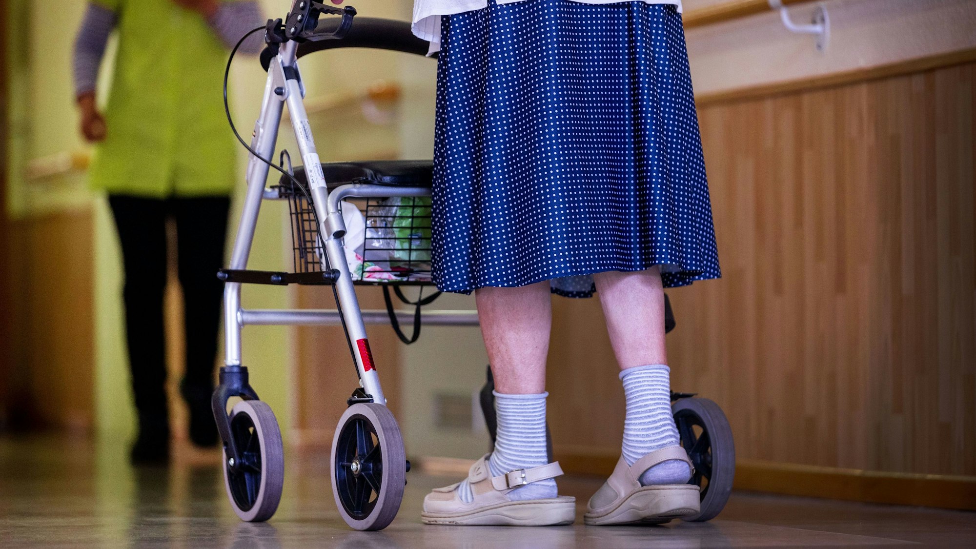 ARCHIV - 17.07.2022, Mecklenburg-Vorpommern, Parchim: Eine Bewohnerin ist mit ihrem Rollator auf dem Flur eines Alten- und Pflegeheims unterwegs. (zu dpa: «Barmer-Pflegereport: Deutlich mehr Pflegebedürftige in MV») Foto: Jens Büttner/dpa +++ dpa-Bildfunk +++