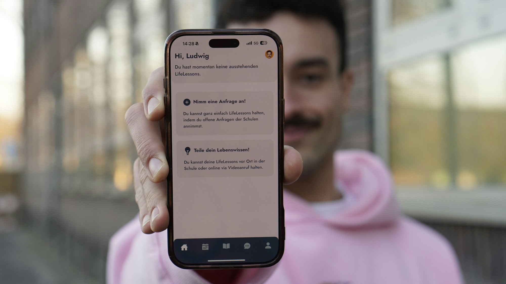 Ein Mann hält ein Handy in die Kamera.