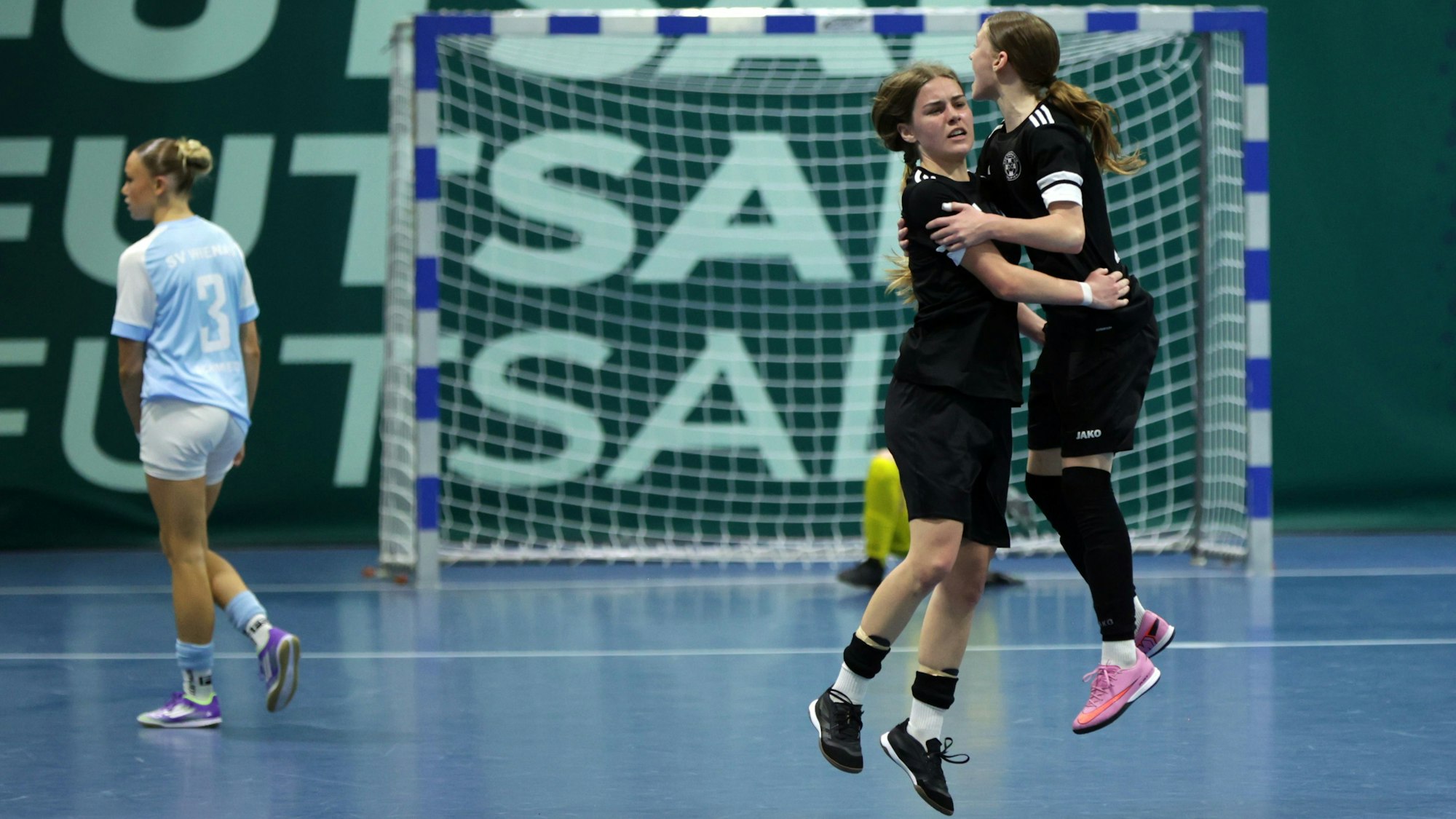 Zwei Zülpicher Spielerinnen jubeln miteinander, eine Gegenspielerin im Hintergrund dreht sich enttäuscht ab.