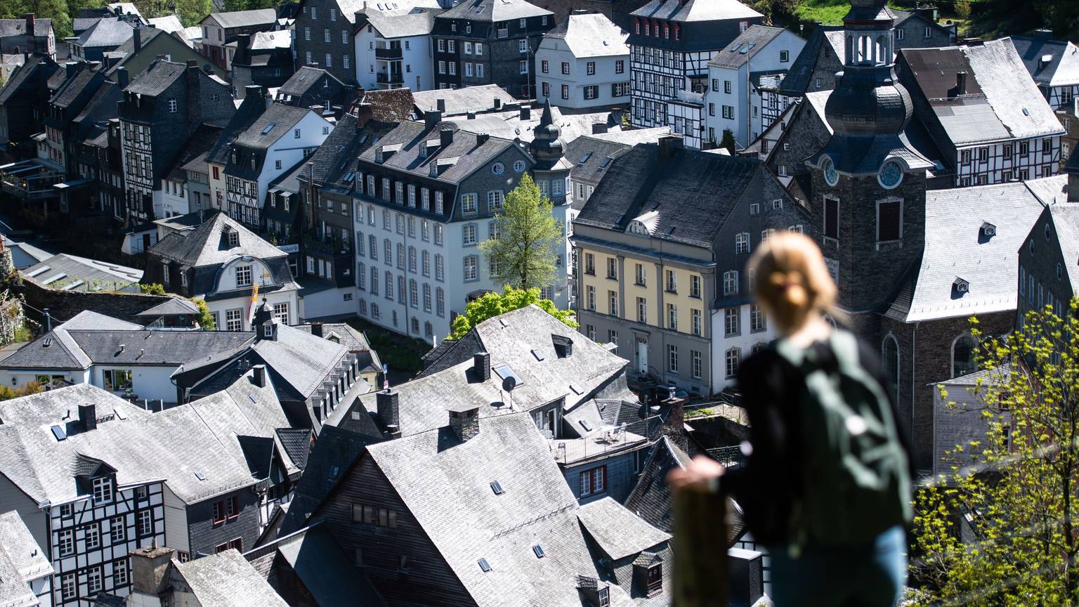 Eine Frau steht auf einem Pfad über den Dächern der Altstadt von Monschau in der Eifel (Symbolfoto).