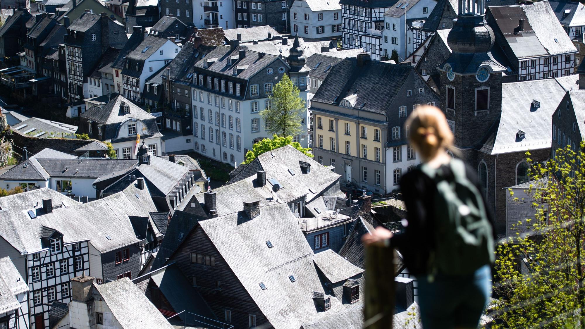 Eine Frau steht auf einem Pfad über den Dächern der Altstadt von Monschau in der Eifel (Symbolfoto).
