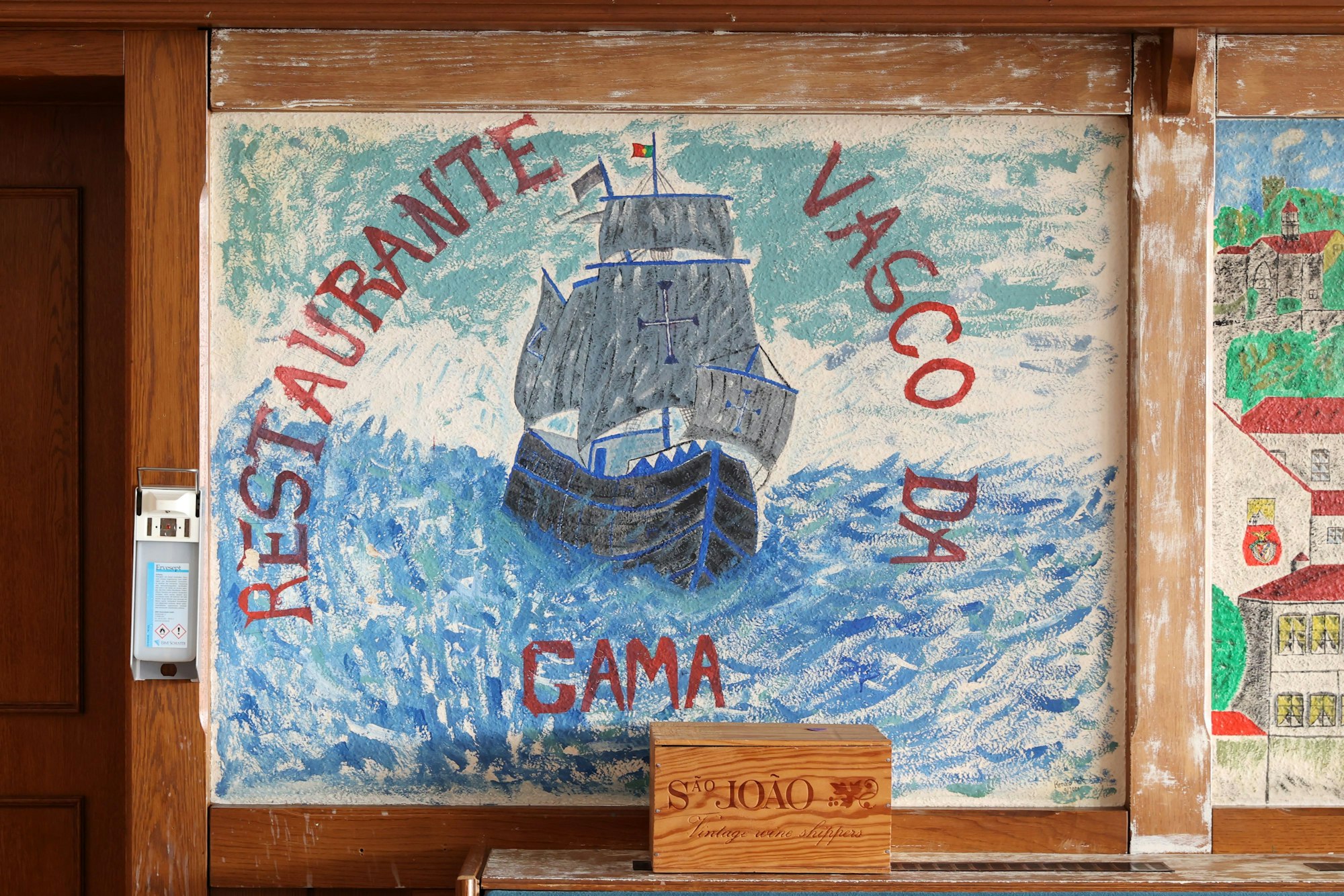 Ein Wandbild mit der Aufschrift Restaurante Vasco da Gama ist zu sehen, es wirkt wie selbst gemalt.