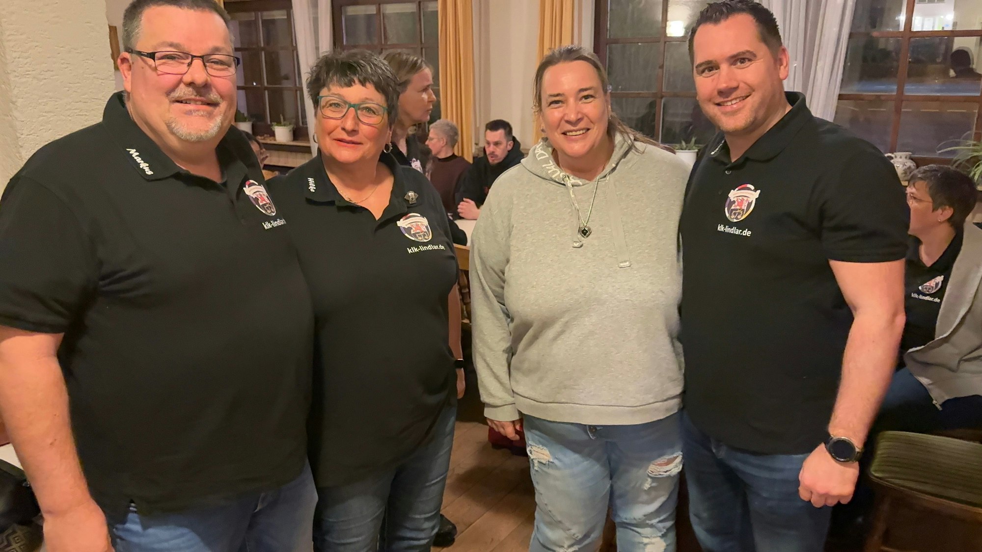 Zwei Frauen und zwei Männer posieren für die Kamera.