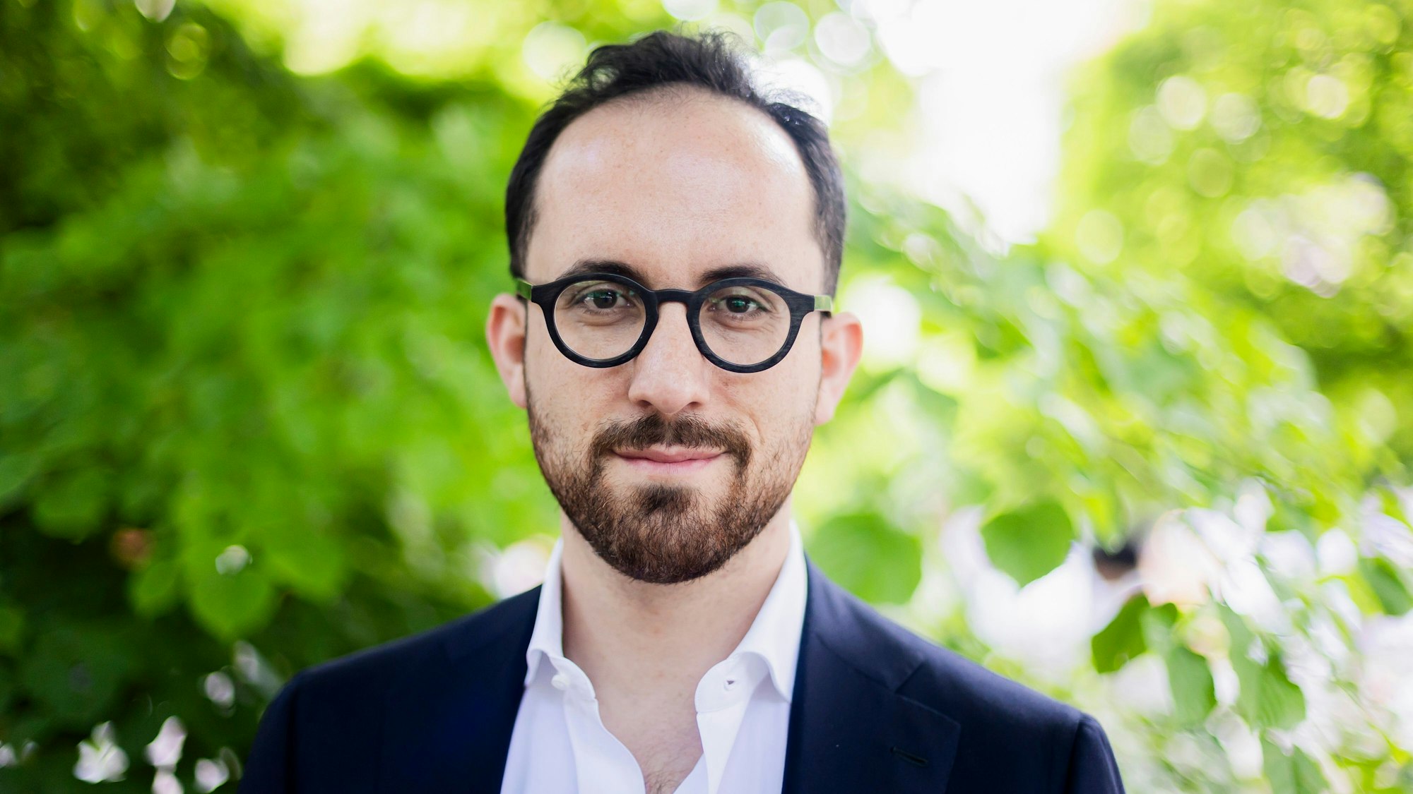 Ein Mann lächelt in die Kamera.