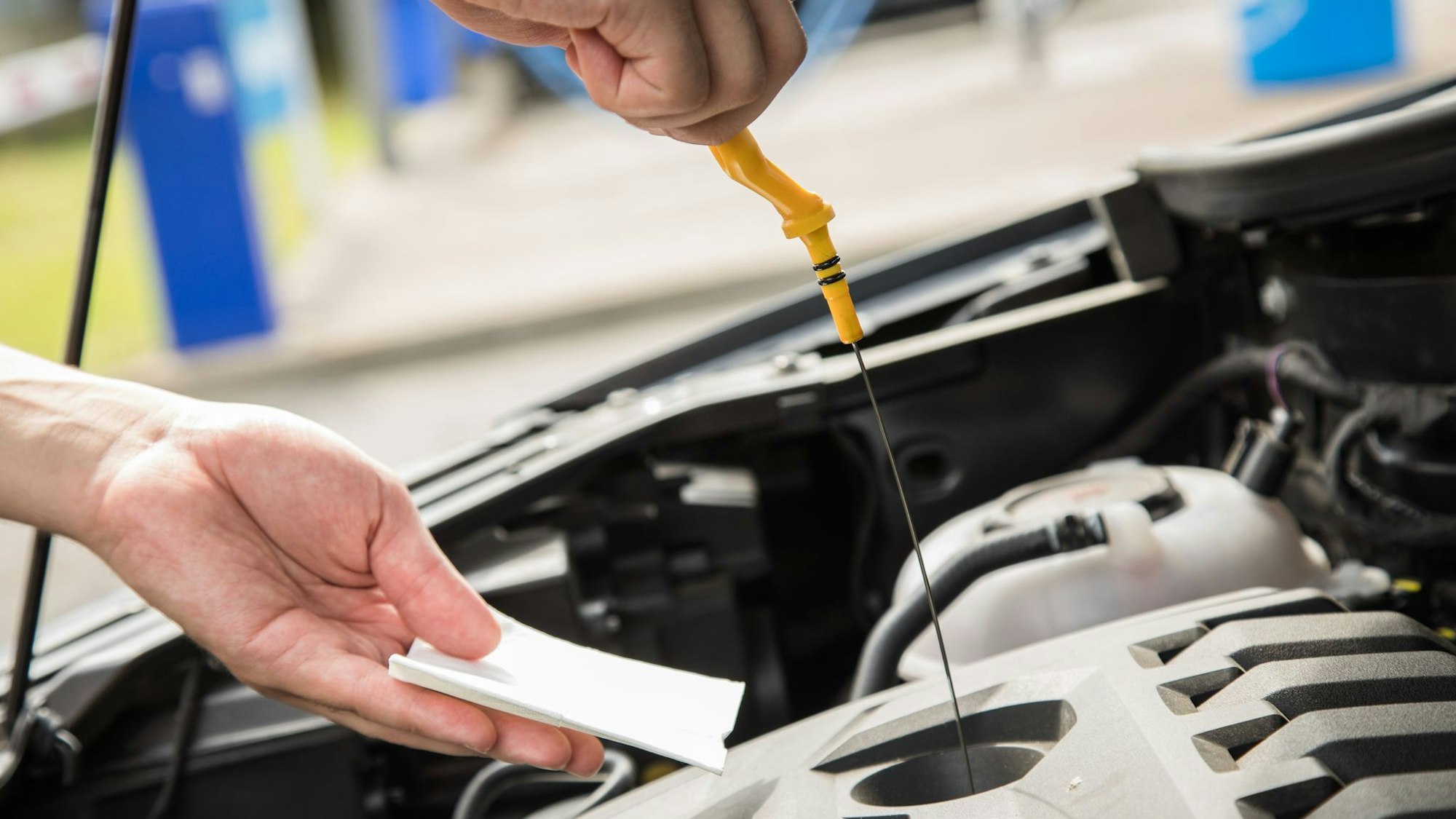 Ein Mann prüft den Ölstand seines Autos