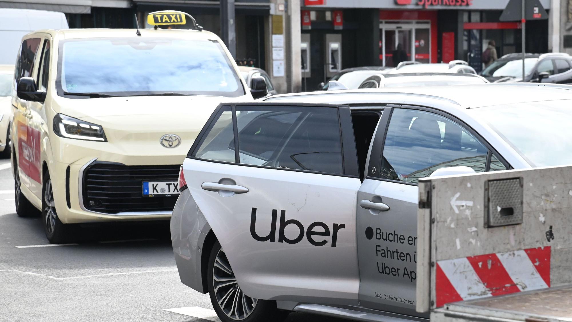 Ein Uber-Fahrzeug nimmt am Kölner Neumarkt einen Fahrgast auf (Archivbild).