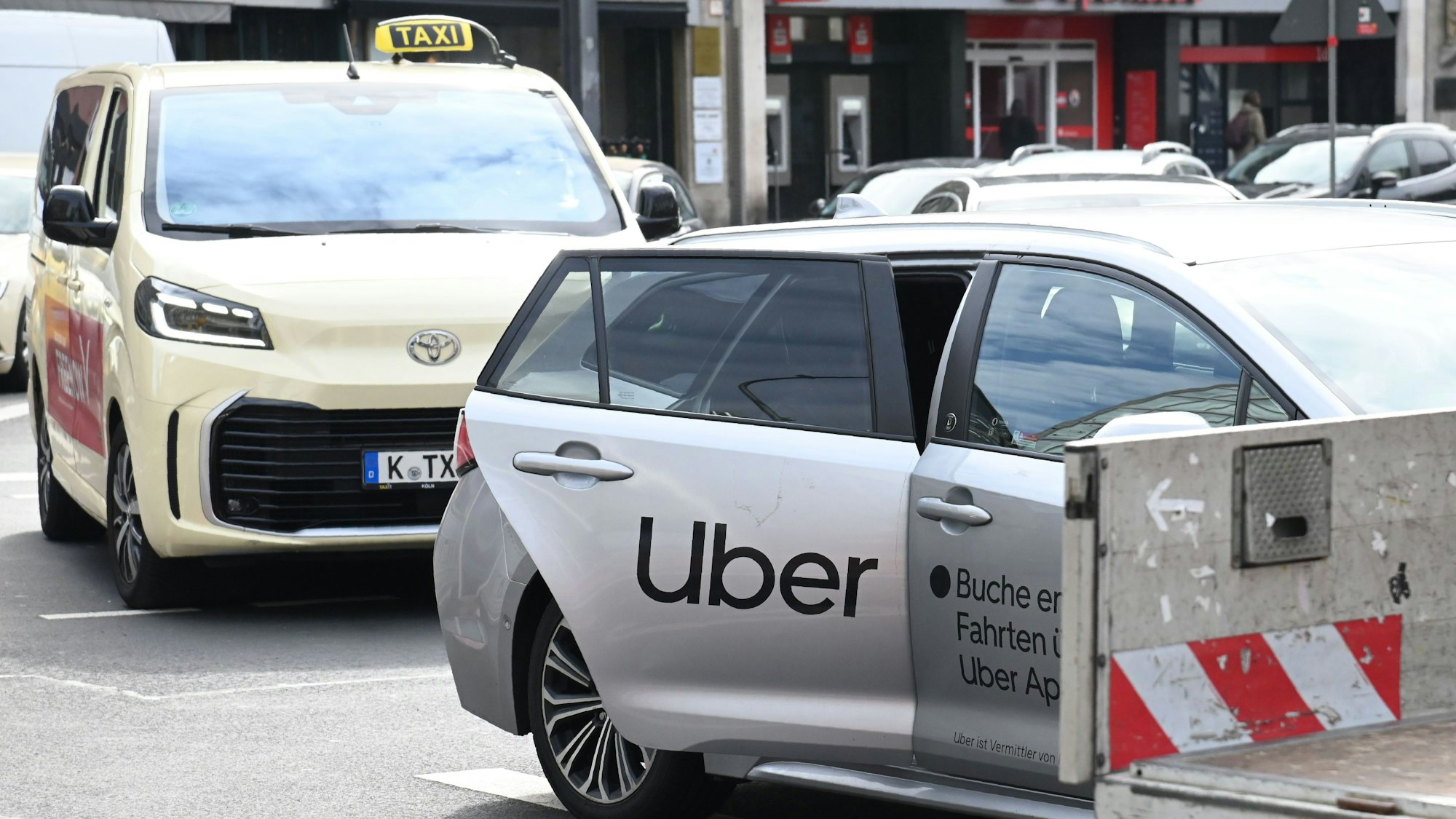 Ein Taxi und ein Über-Fahrzeug am Kölner Neumarkt