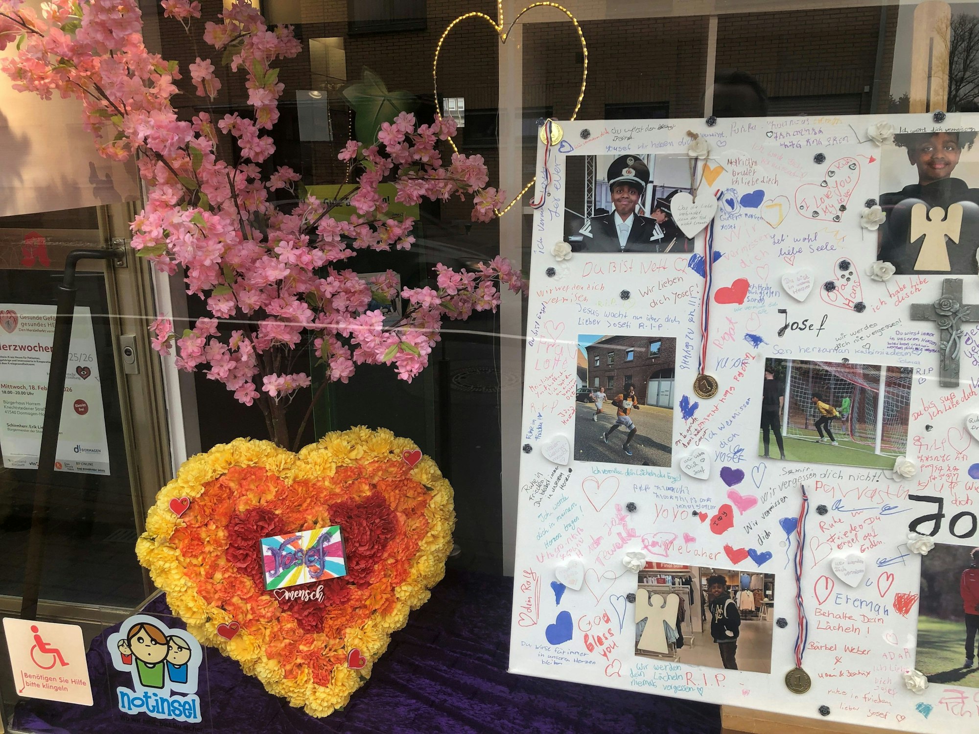 Ein mit Herzen, Bildern und Beileidsbekundungen gestaltetes Schaufenster.