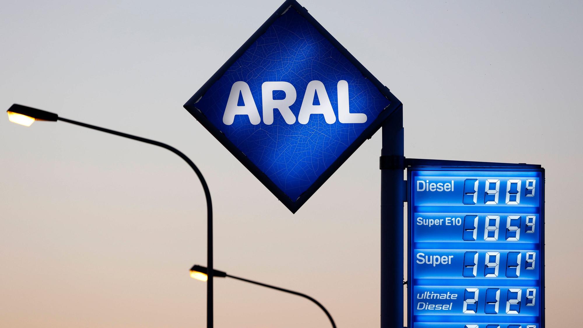 Tankstellenanzeige mit Preisen und Straßenlaternen