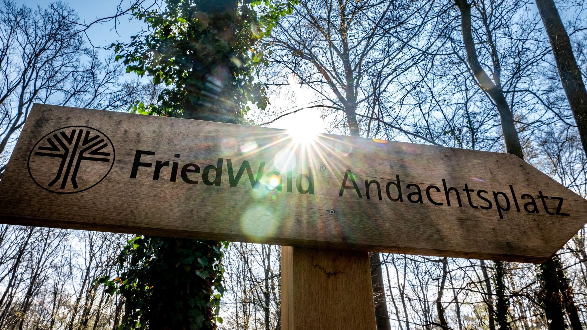 Das Bild zeigt ein Holzschild, das auf den Andachtsplatz im Friedwald hinweist.