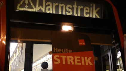 „Warnstreik“ steht auf der Anzeige einer Stadtbahn in Köln. Dort sollen Busse und Bahnen am Sonntag fahren - anders als in Teilen von NRW.