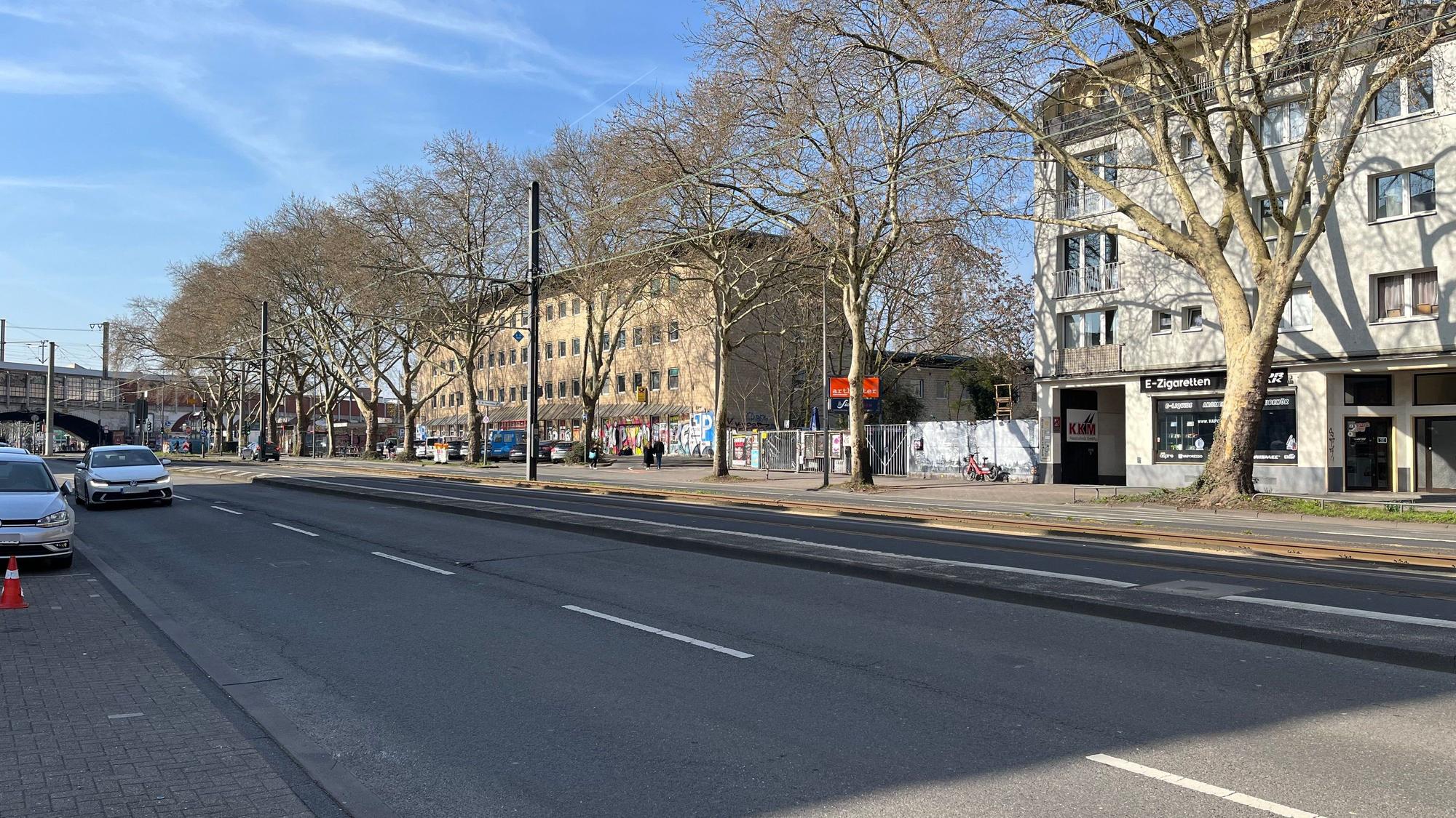 Der Ehrenfeldgürtel mit dem alten Postamt (helles Gebäude) und Artheater und Bumann & Sohn sowie dem Bahndamm im Hintergrund.