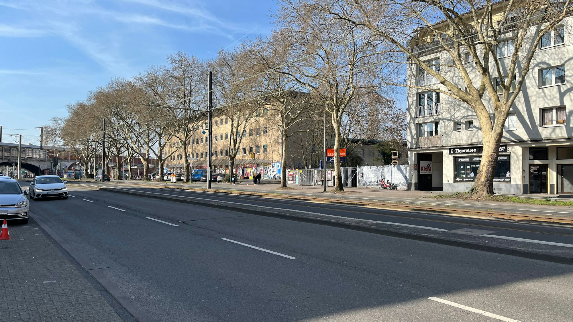 Der Ehrenfeldgürtel mit dem alten Postamt (helles Gebäude) und Artheater und Bumann & Sohn sowie dem Bahndamm im Hintergrund.