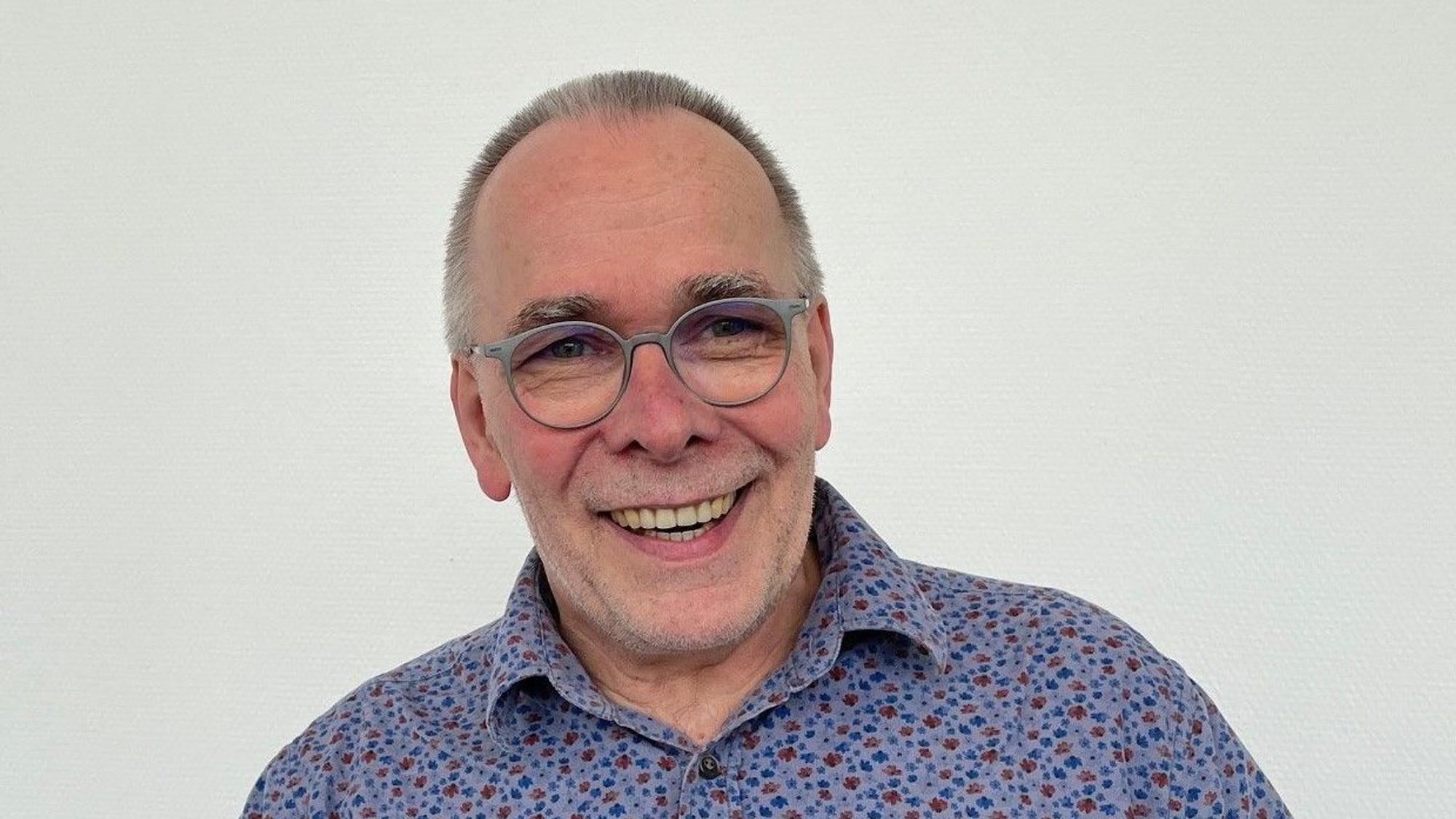 Martin Süsterhenn, Schulleiter der Katharina-Henoth-Gesamtschule, trägt ein buntes Hemd und eine graue Brille