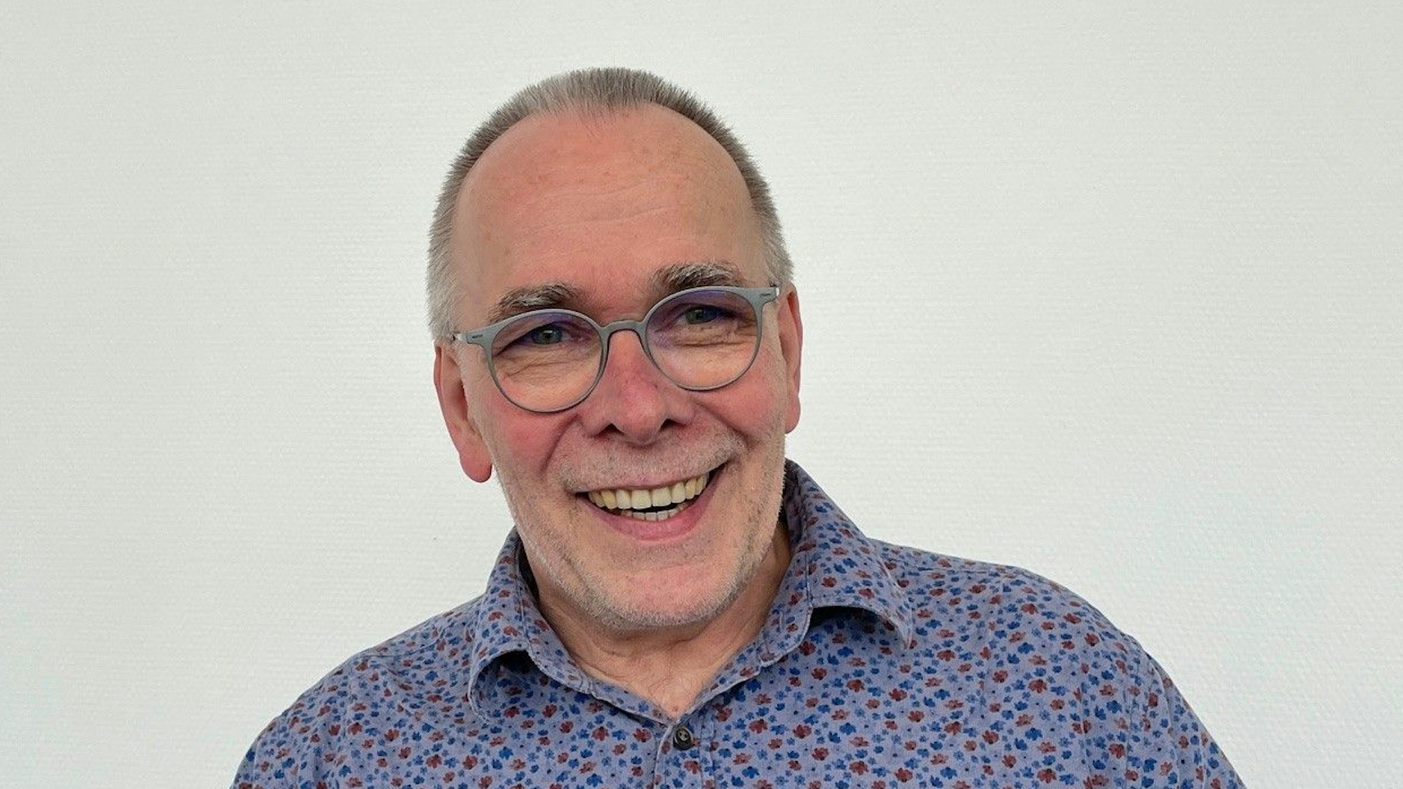 Martin Süsterhenn, Schulleiter der Katharina-Henoth-Gesamtschule, trägt ein buntes Hemd und eine graue Brille