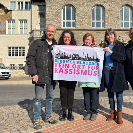 Fünf Vertreter der Stadt halten die Fahne in die Kamera.