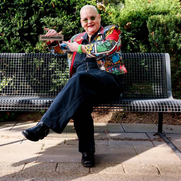 Komikerin Hella von Sinnen auf einer Bank am Grab von Schauspieler und Komiker Dirk Bach auf dem Friedhof Melaten in Köln.