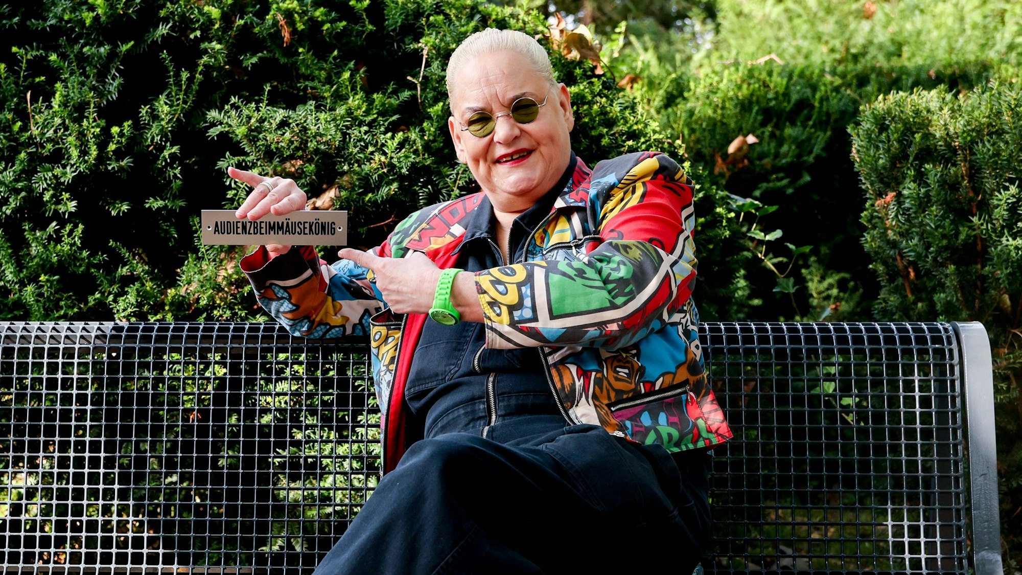 Komikerin Hella von Sinnen auf einer Bank am Grab von Schauspieler und Komiker Dirk Bach auf dem Friedhof Melaten in Köln.