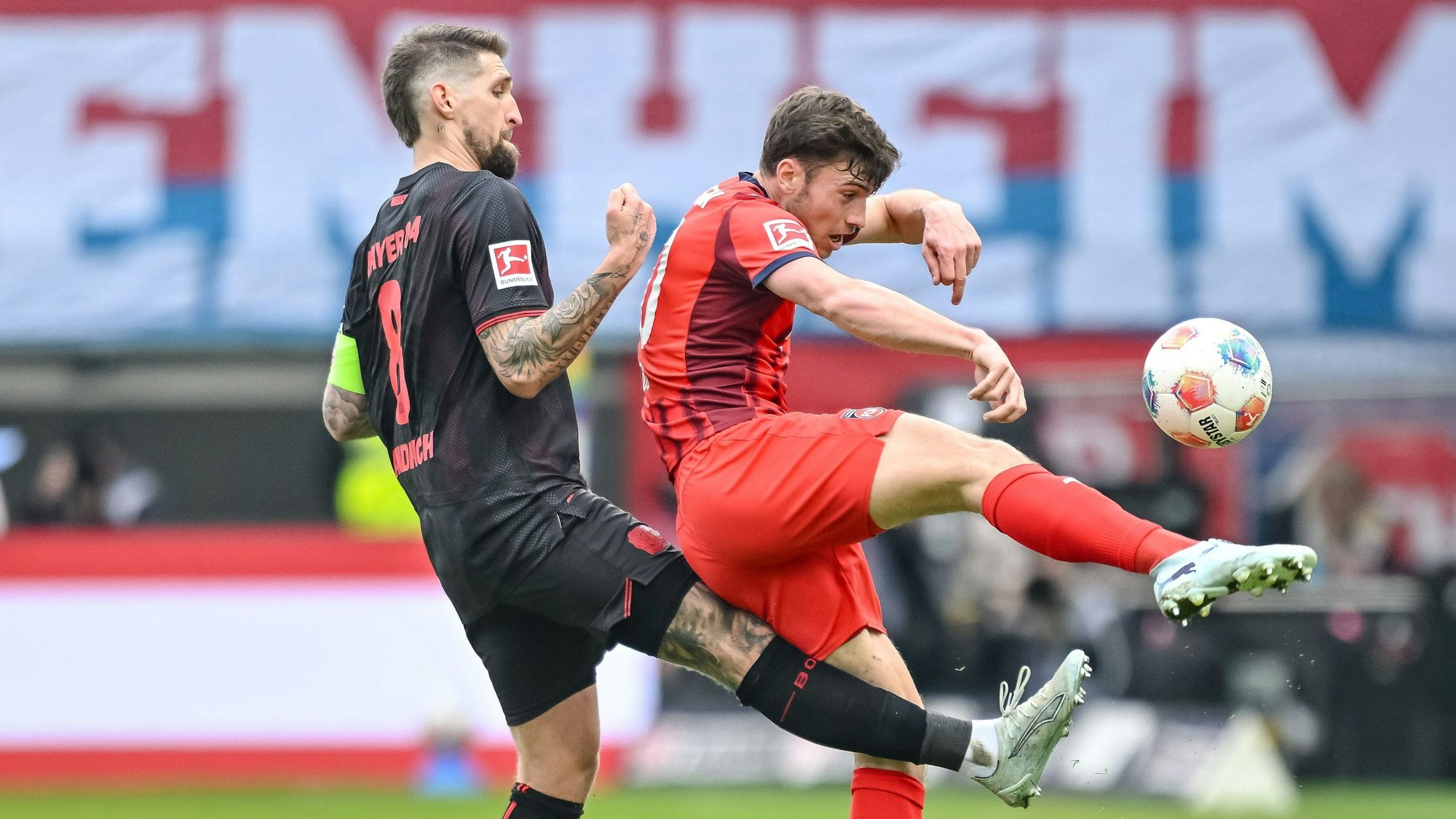 21.03.2026, Baden-Württemberg, Heidenheim: Fußball, Männer: Bundesliga, 1. FC Heidenheim - Bayer Leverkusen, 27. Spieltag, Voith-Arena. Robert Andrich (l, Bayer 04 Leverkusen) in Aktion gegen Luca Kerber (1. FC Heidenheim 1846). Foto: Harry Langer/dpa - WICHTIGER HINWEIS: Gemäß den Vorgaben der DFL Deutsche Fußball Liga bzw. des DFB Deutscher Fußball-Bund ist es untersagt, in dem Stadion und/oder vom Spiel angefertigte Fotoaufnahmen in Form von Sequenzbildern und/oder videoähnlichen Fotostrecken zu verwerten bzw. verwerten zu lassen. +++ dpa-Bildfunk +++