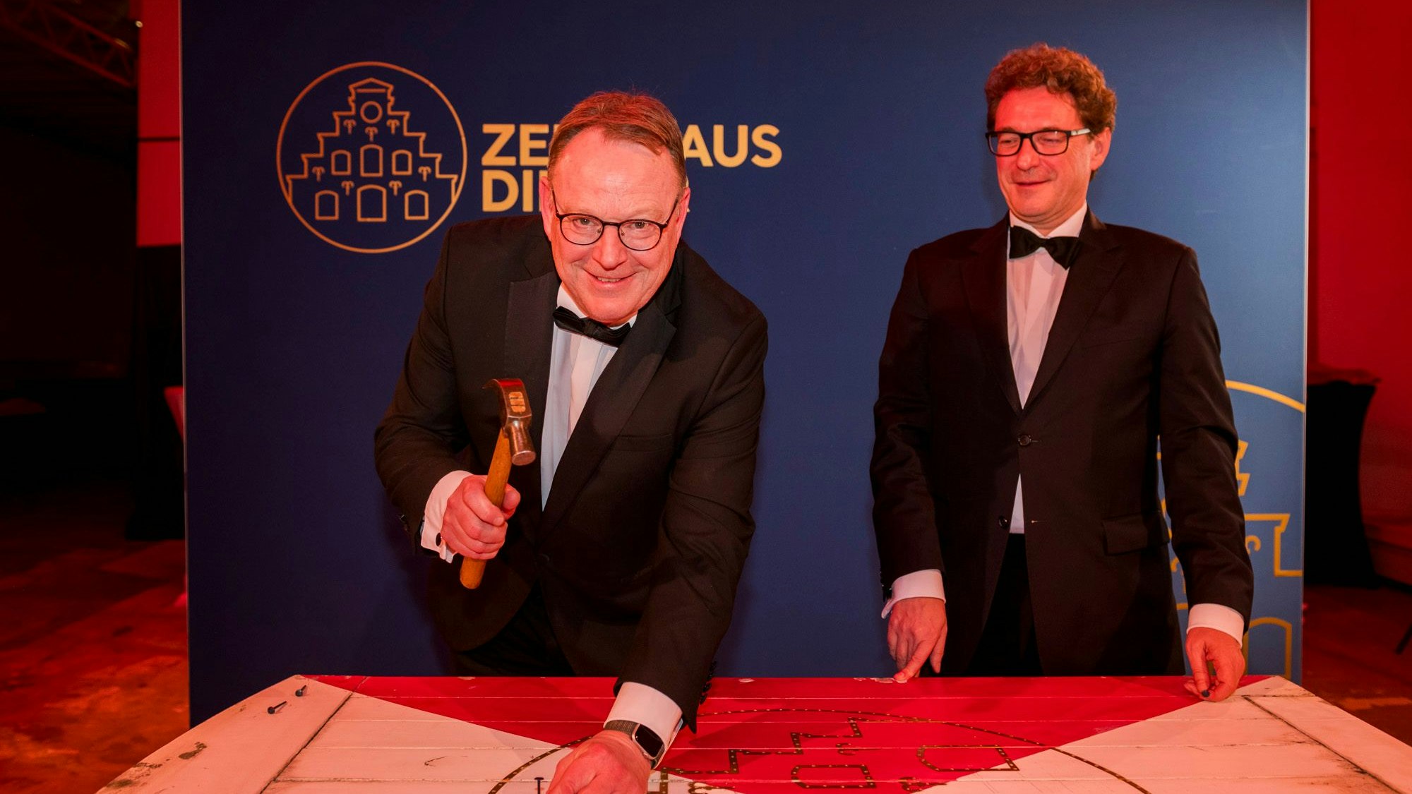 Torsten Burmester schlägt einen Nagel in einen Fensterladen des Zeughauses ein