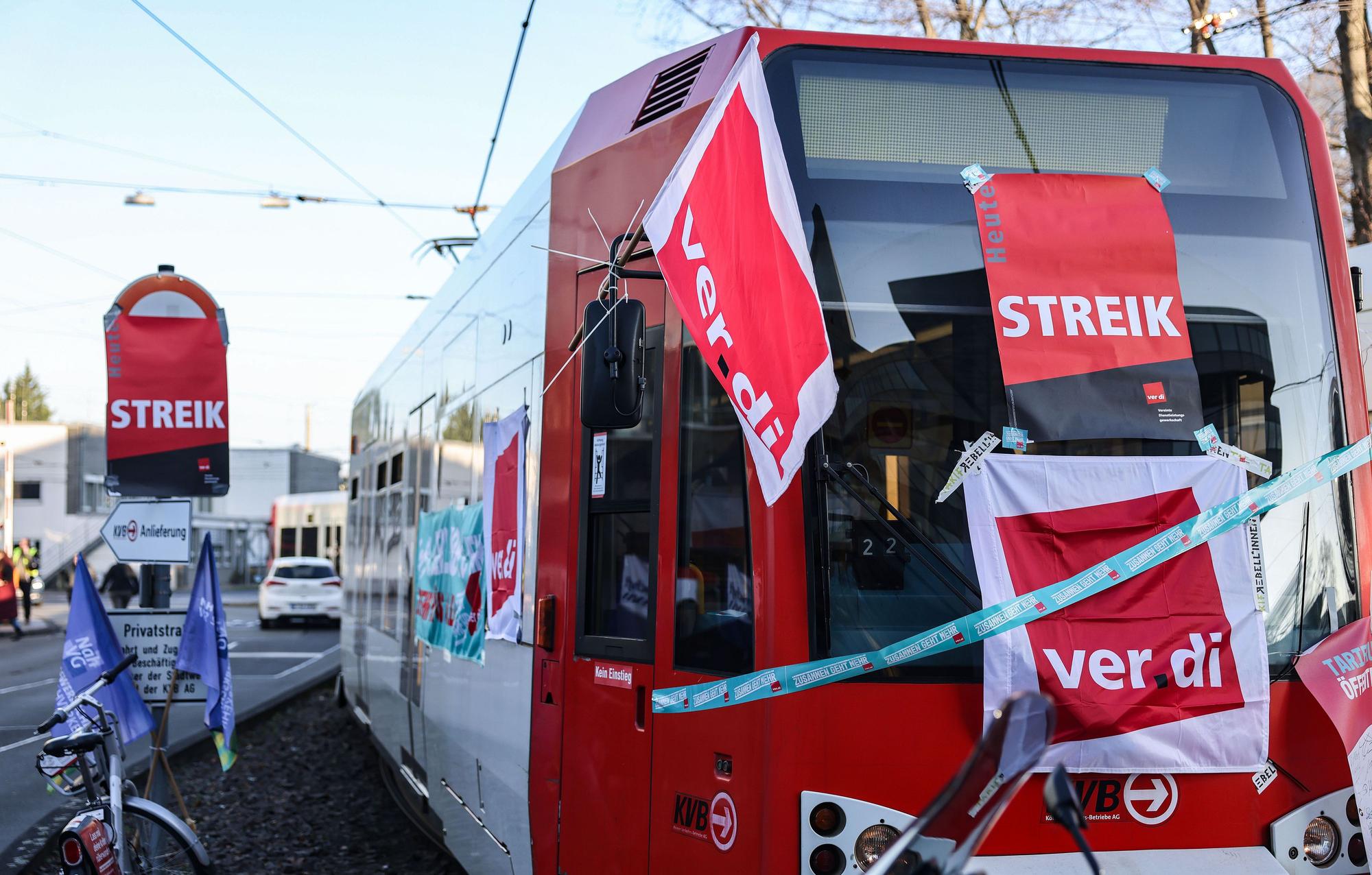 ARCHIV - 14.02.2023, Nordrhein-Westfalen, Köln: Eine mit Streik-Plakaten beklebte Straßenbahn der Kölner Verkehrs-Betriebe (KVB) steht vor dem Bahndepot. Die Warnstreiks im Nahverkehr von NRW starten am Niederrhein schon am Donnerstag. (zu dpa: «Auch am Montag wieder Ausfälle bei Bahnen und Bussen möglich») Foto: Oliver Berg/dpa +++ dpa-Bildfunk +++