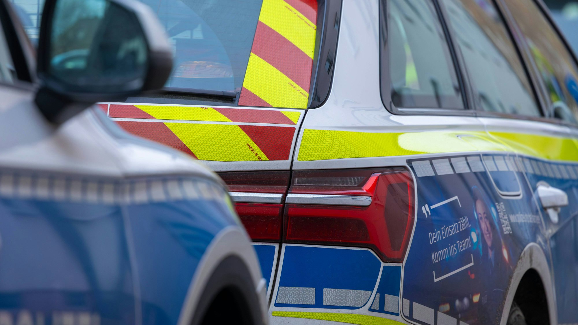 Zwei Polizeifahrzeuge stehen hintereinander.