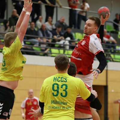 Voiß hat zum Sprungwurf angesetzt, ein Abwehrspieler versucht zu blocken.