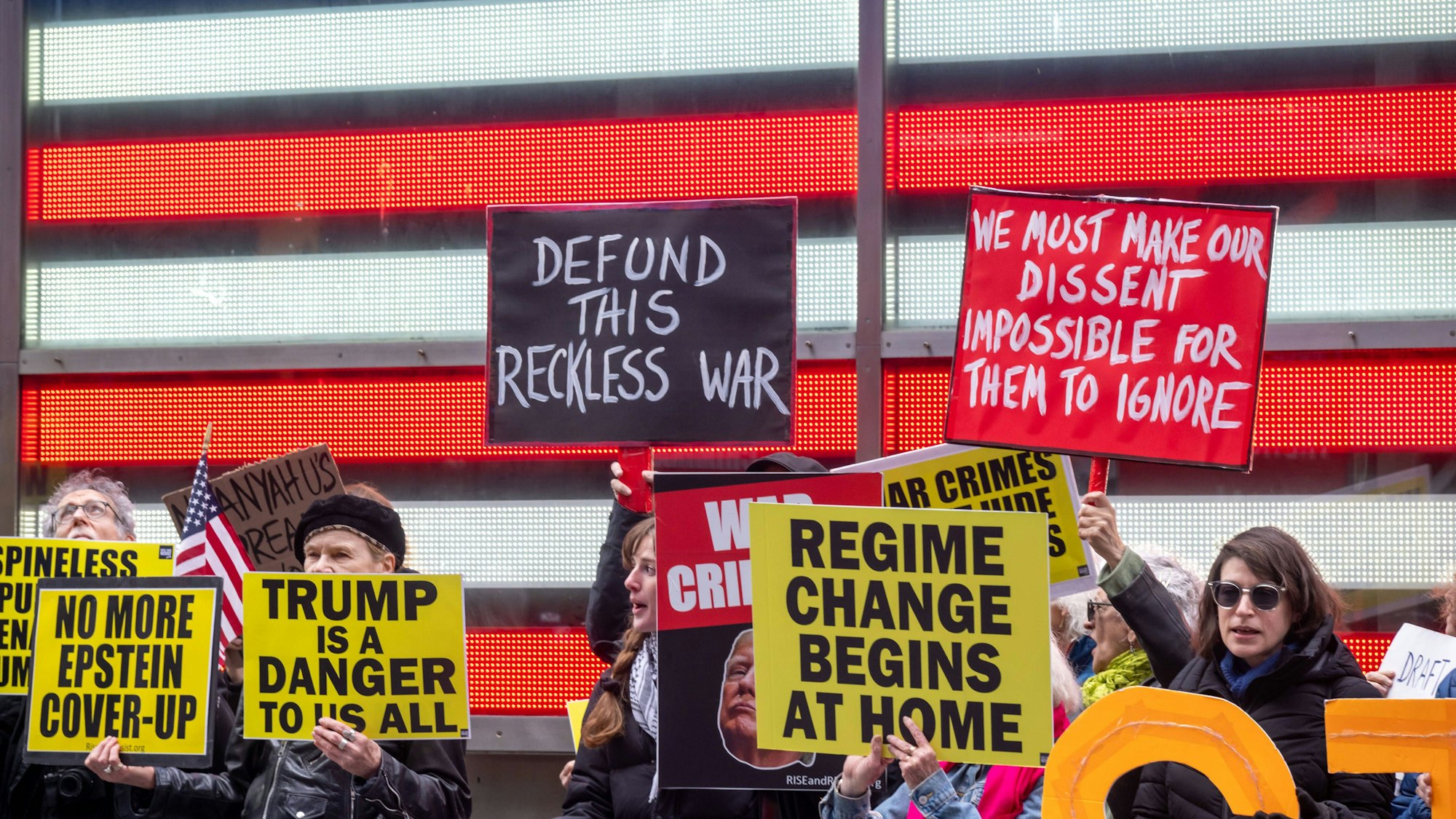Menschen protestieren mit Schildern gegen Donald Trump
