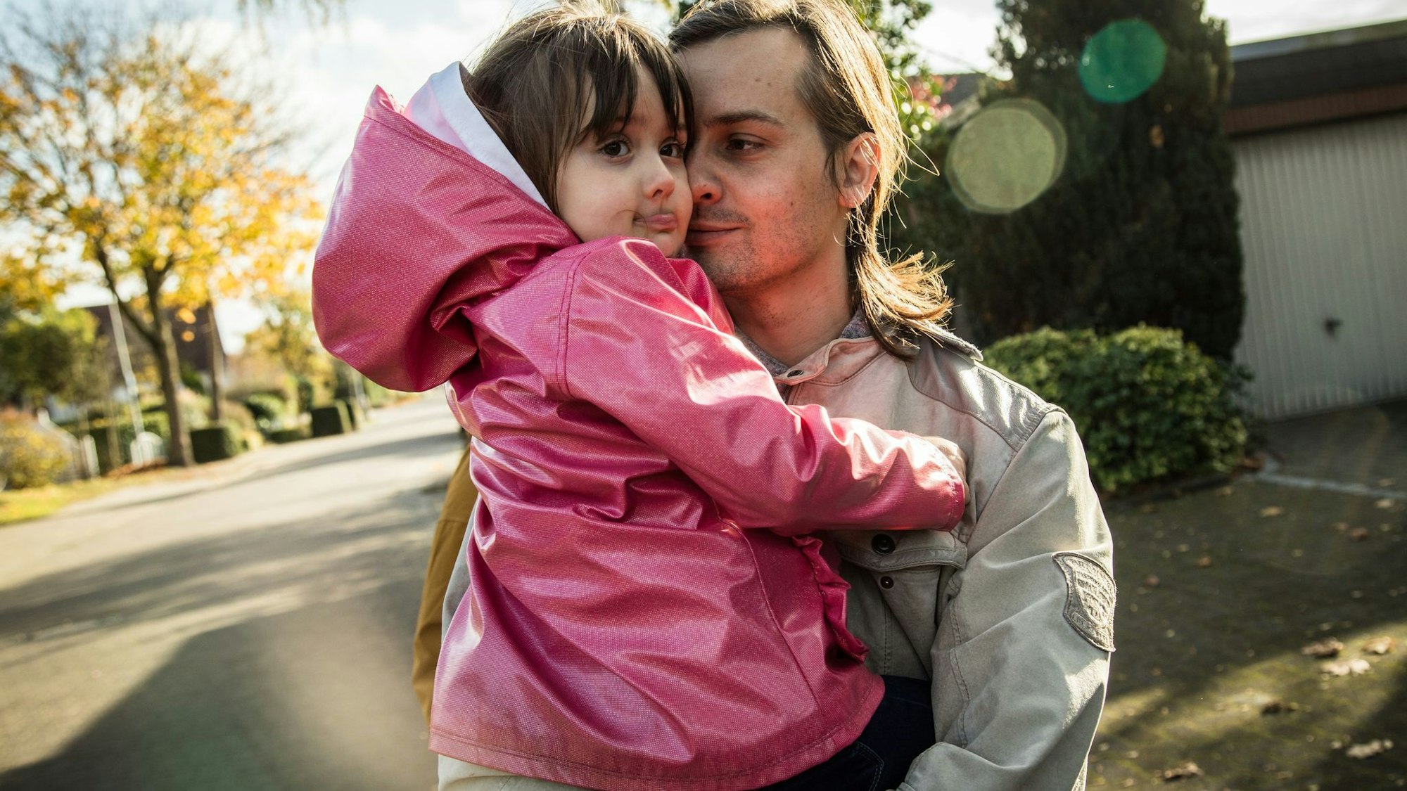 Vater hält schmollende Tochter auf dem Arm