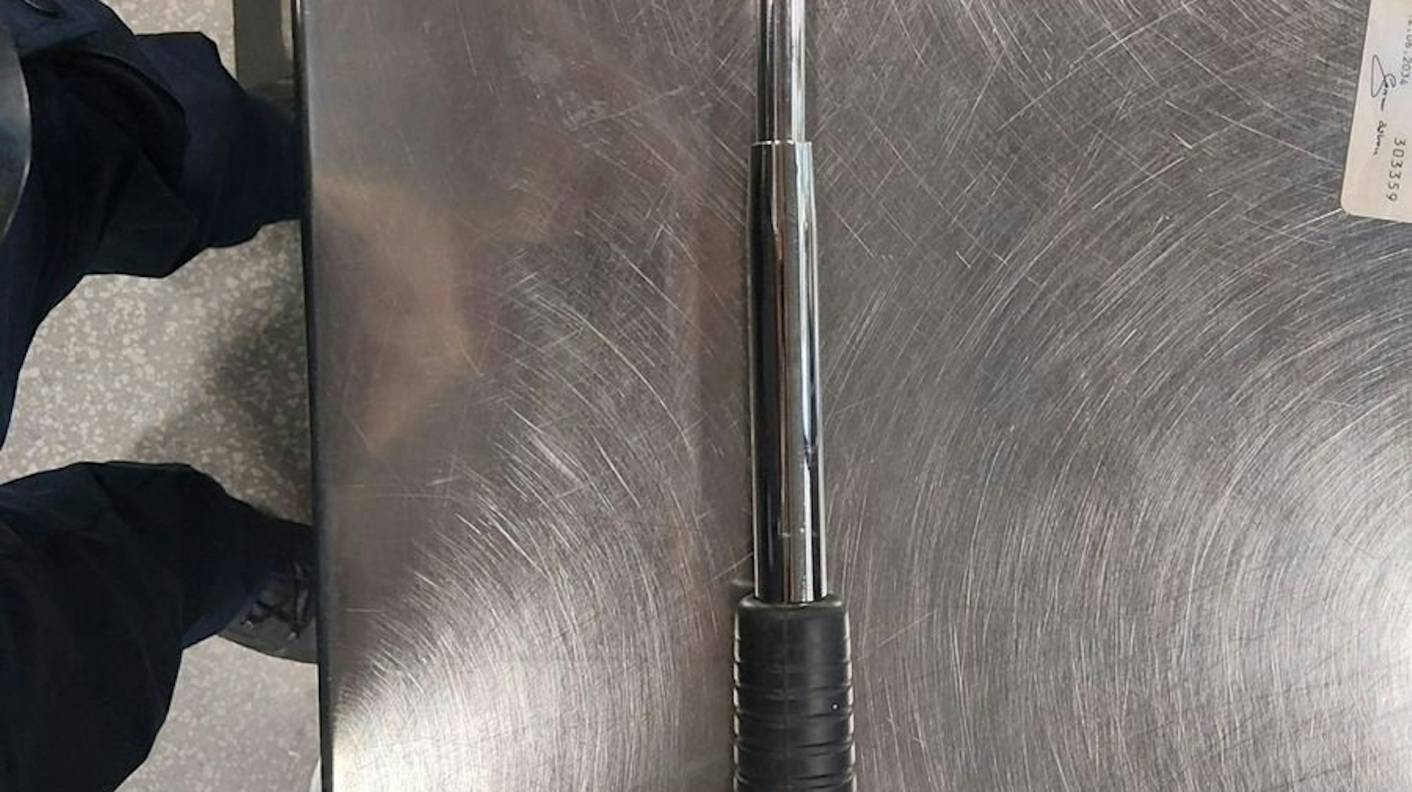 Ein Teleskopschlagstock liegt auf dem Boden.