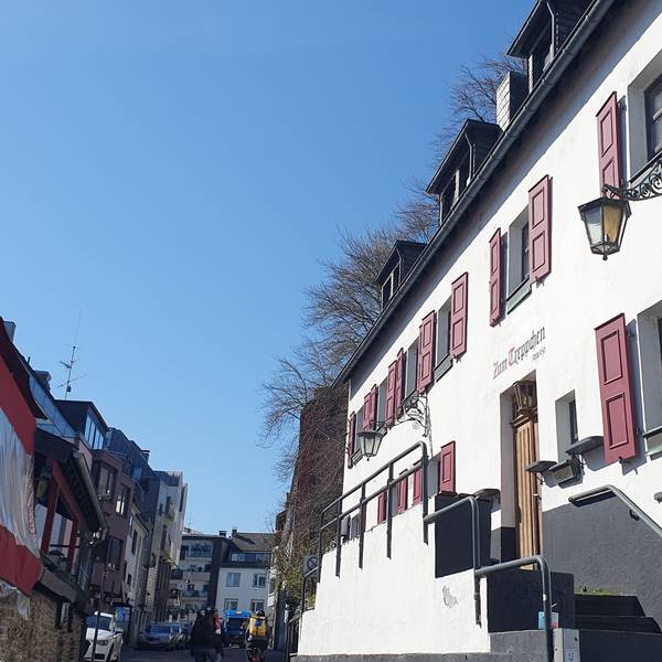 Ein großes altes Haus mit roten Fensterläden ist zu sehen.