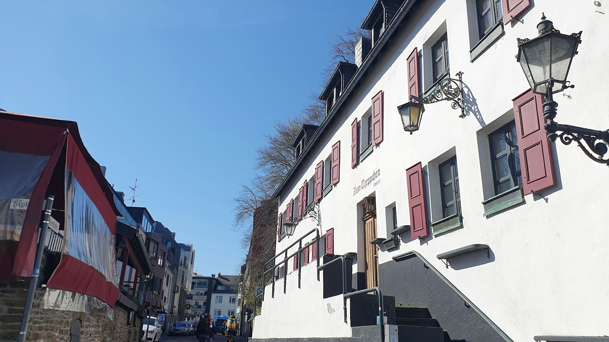Ein großes altes Haus mit roten Fensterläden ist zu sehen.