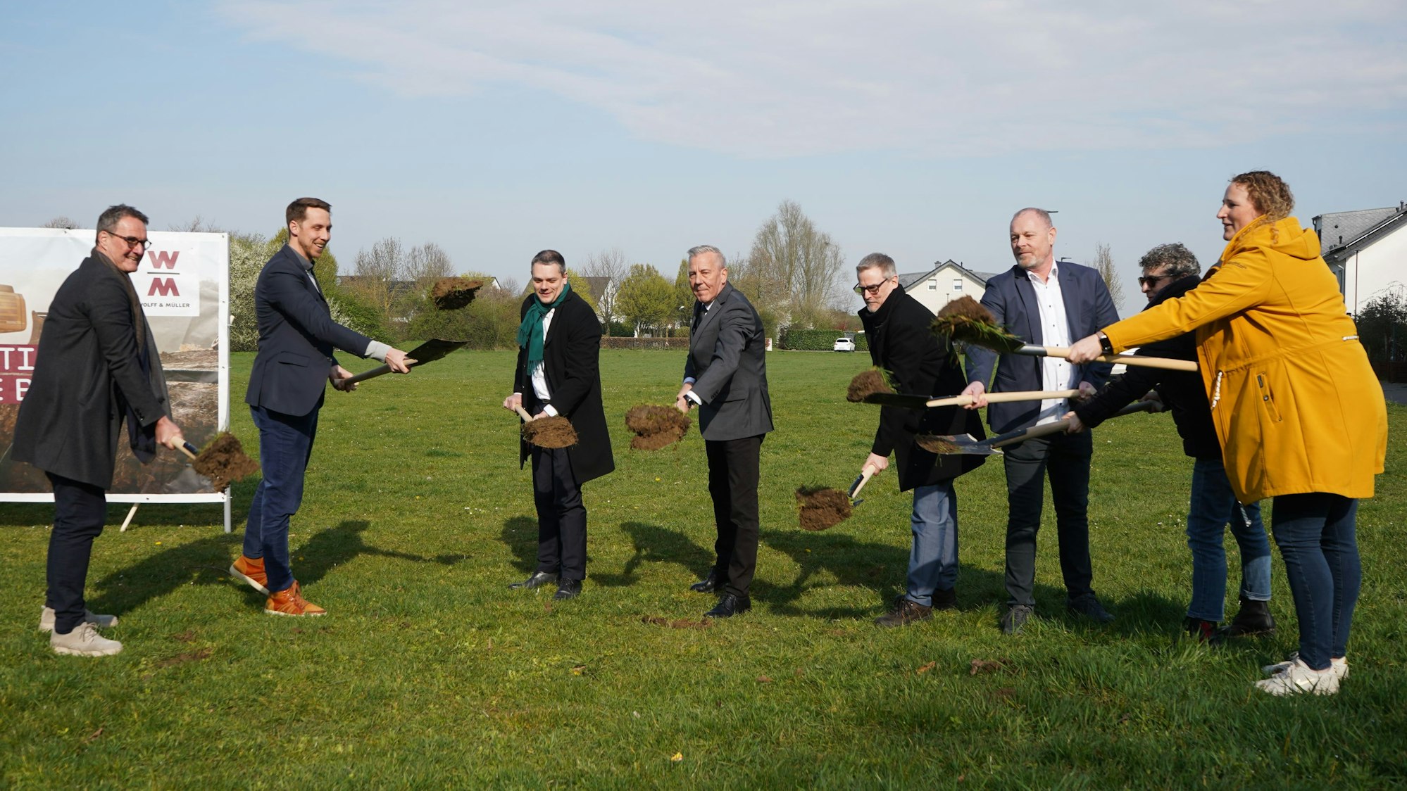 Das Foto zeigt eine Gruppe von Menschen, die Erde wegschaufeln.