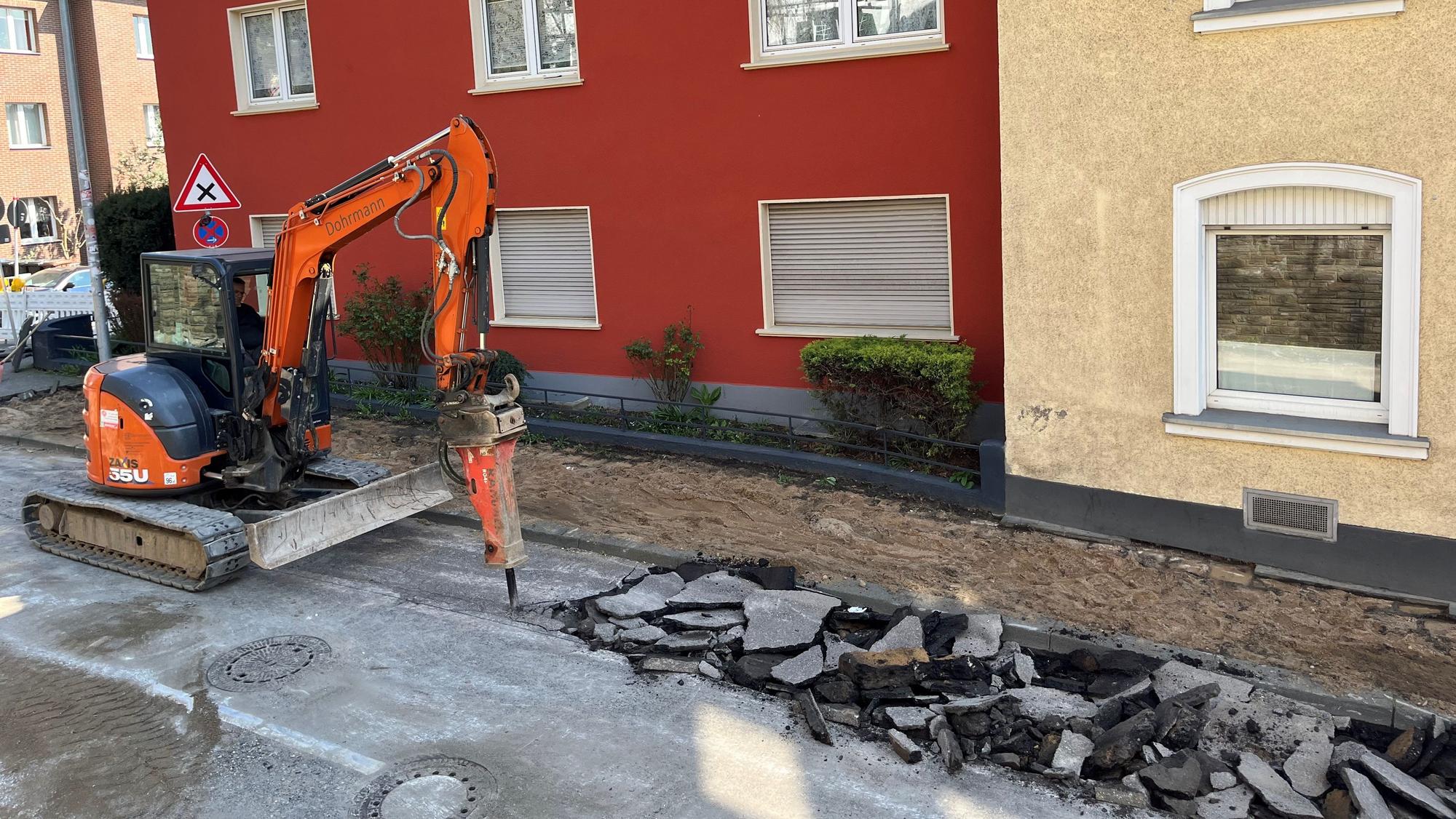 Ein Bagger stemmt die Straße auf.