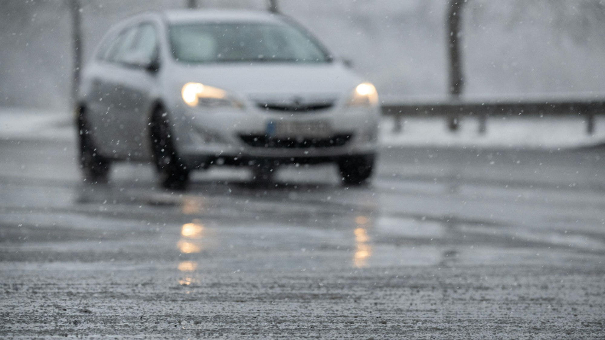 Schneematsch liegt vor einem Auto auf der Straße (Archivbild). Auch in Köln wird es wieder kalt und ungemütlich.