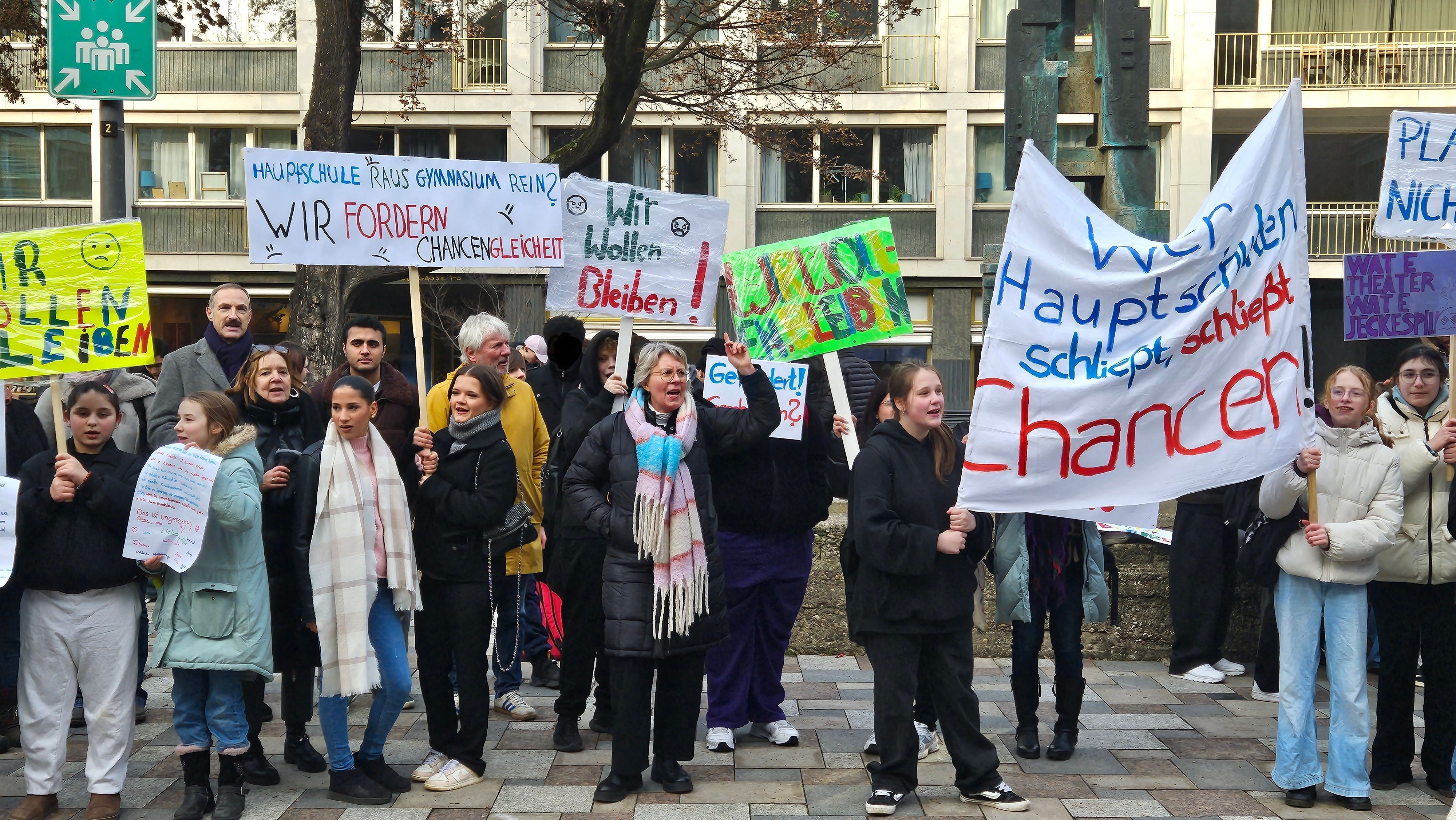 Eltern, Schülerinnen und Schüler und Lehrkräfte demonstrieren vor dem Rathaus.